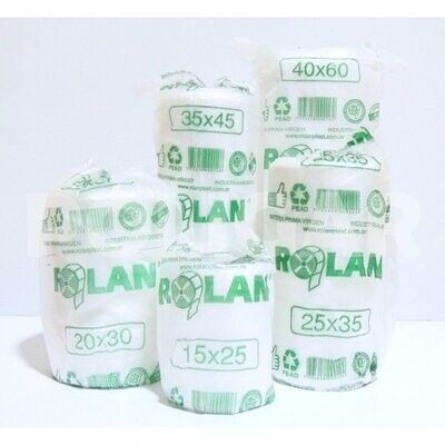 Bolsas de plástico blancas apiladas con etiquetas verdes impresas y de tamaño sobre un fondo liso.