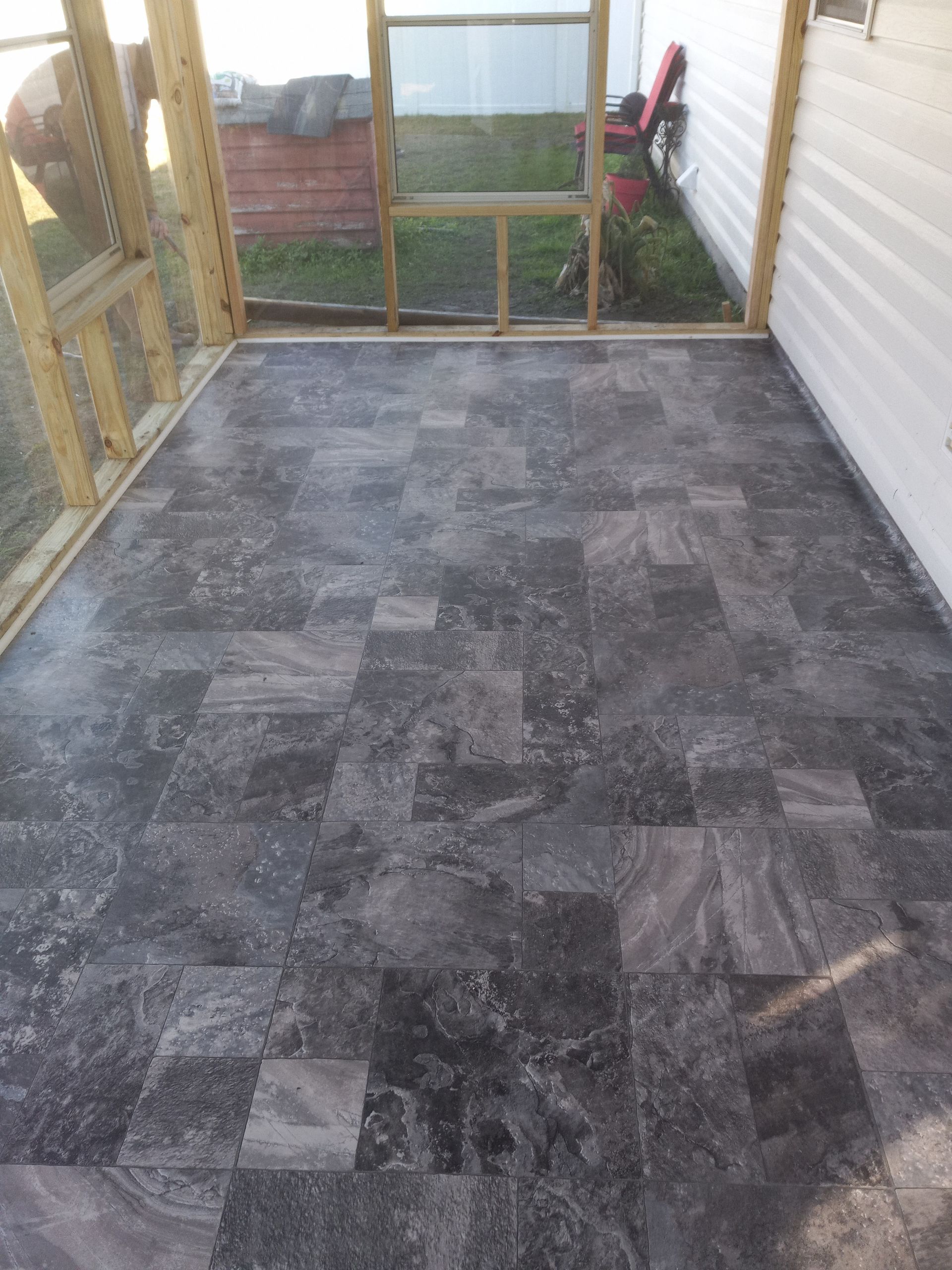 Gray stone tiles arranged in a random pattern on a screened-in porch floor.
