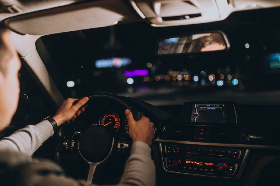 Un hombre conduce un coche de noche.