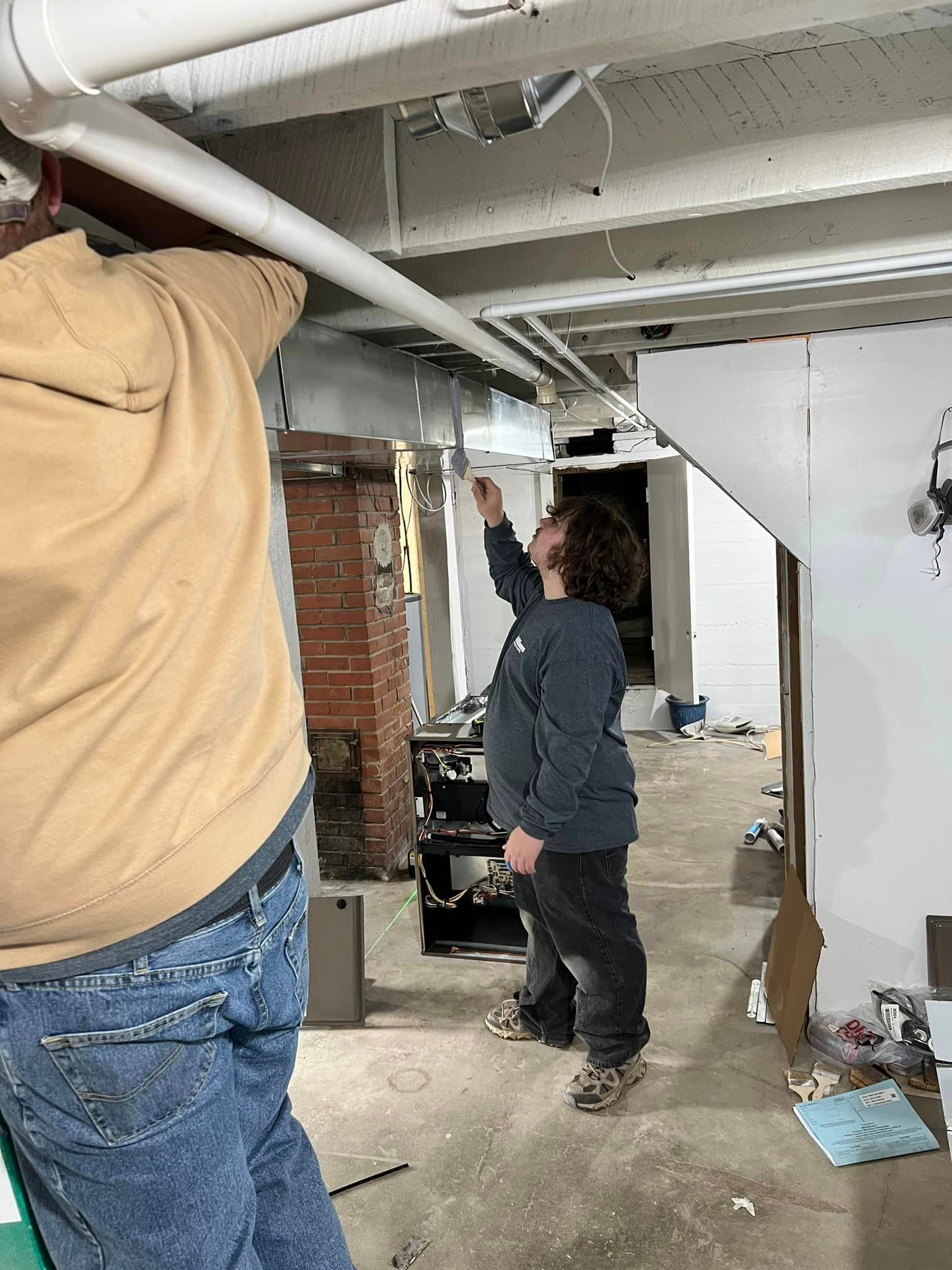 Man and Woman Working on A Pipe in A Basement | Sullivan, MO | Williams heating and cooling