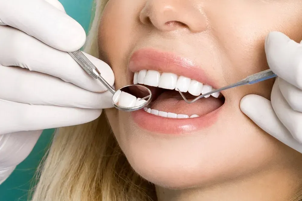 A Woman is Getting Her Teeth Examined by a Dentist — Twin Towns Denture Clinic In Forster, NSW
