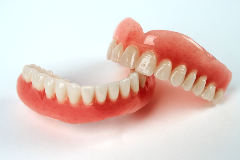 A Close Up of a Pair of Dentures on a White Surface — Twin Towns Denture Clinic In Tea Gardens, NSW