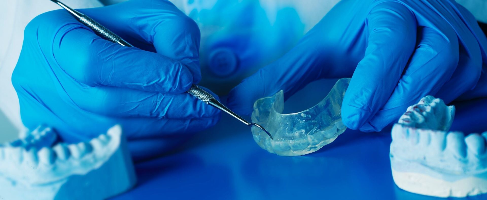 A Dentist is Working on a Model of a Person 's Teeth — Twin Towns Denture Clinic In Gloucester, NSW