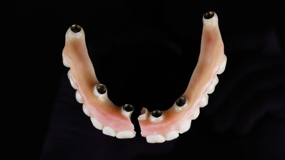 A Close Up of a Denture on a Black Background — Twin Towns Denture Clinic In Tuncurry, NSW