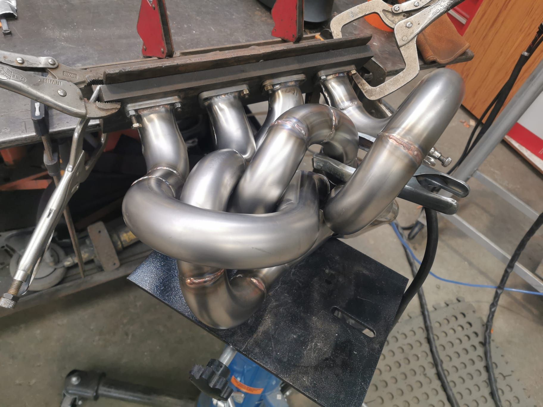 A exhaust pipe is sitting on top of a metal table.