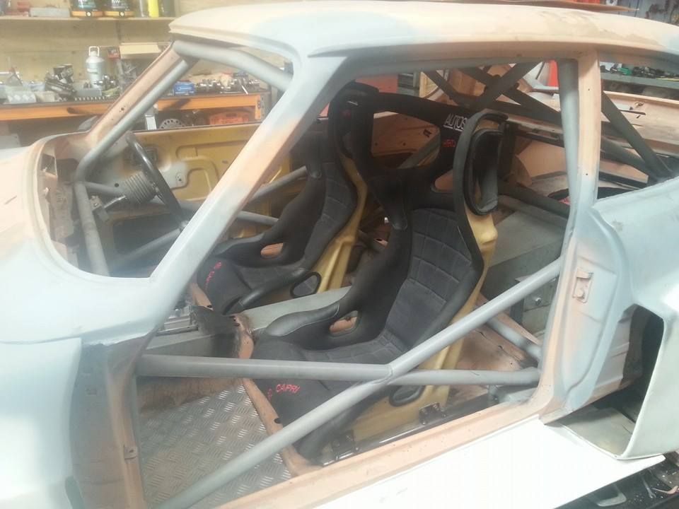The inside of a race car with black seats.