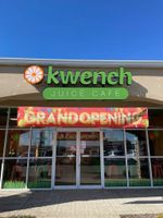 Kwench Juice Cafe storefront with a colorful “Grand Opening” banner and glass entrance