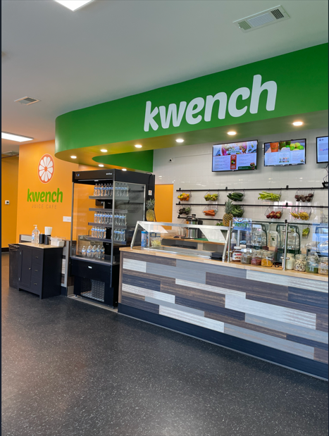 Kwerch café counter with green sign, menu screens, and drink display in a mall food court
