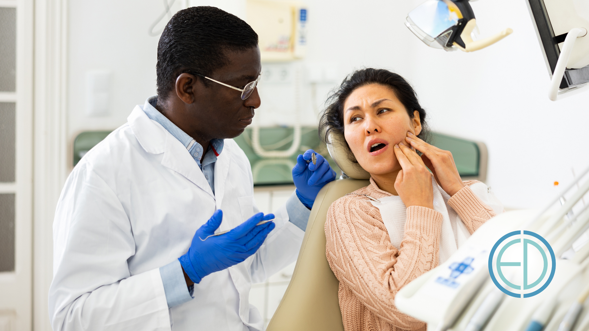 A dentist is talking to a patient in a dental chair.