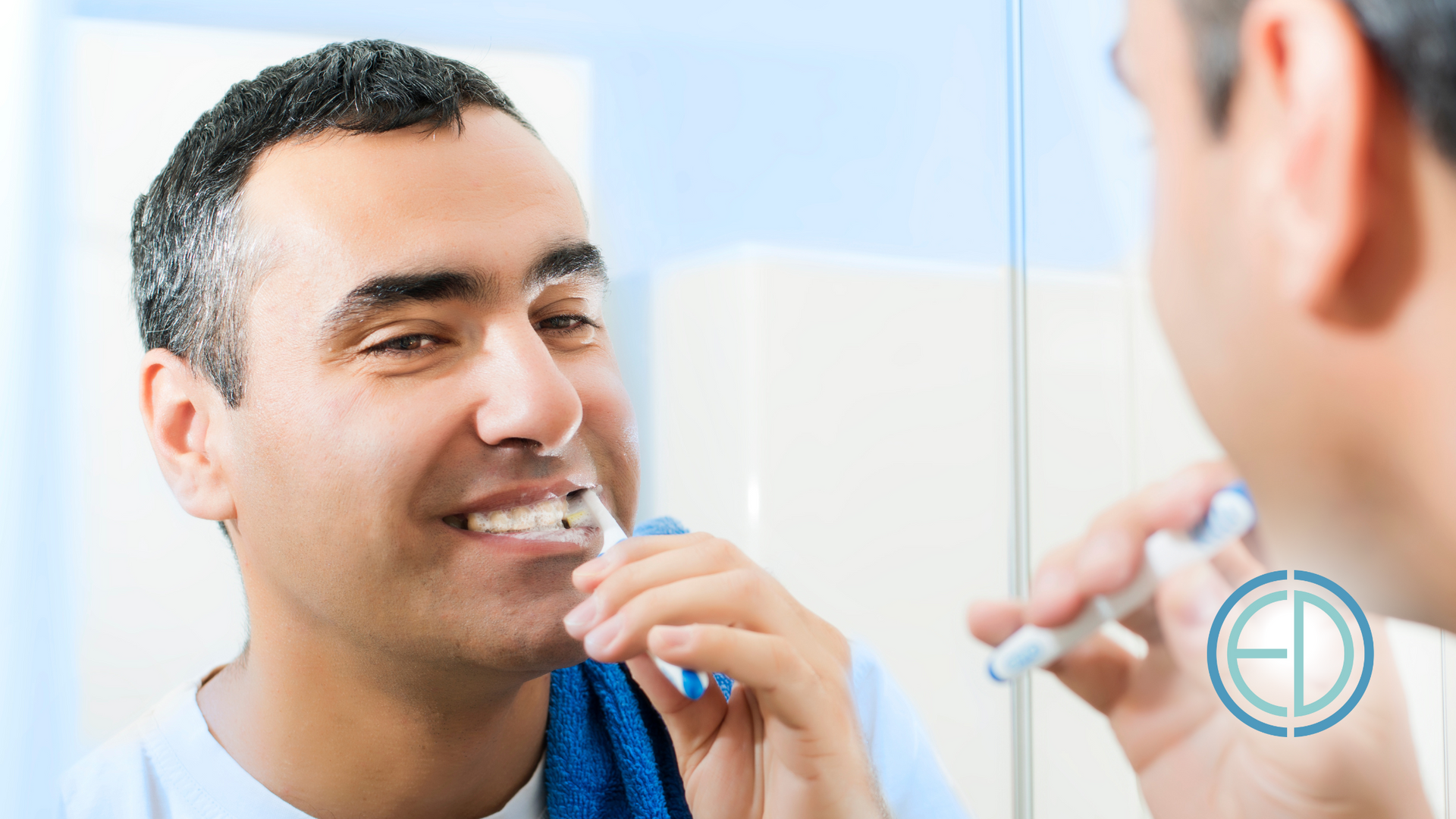 A man is brushing his teeth in front of a mirror.
