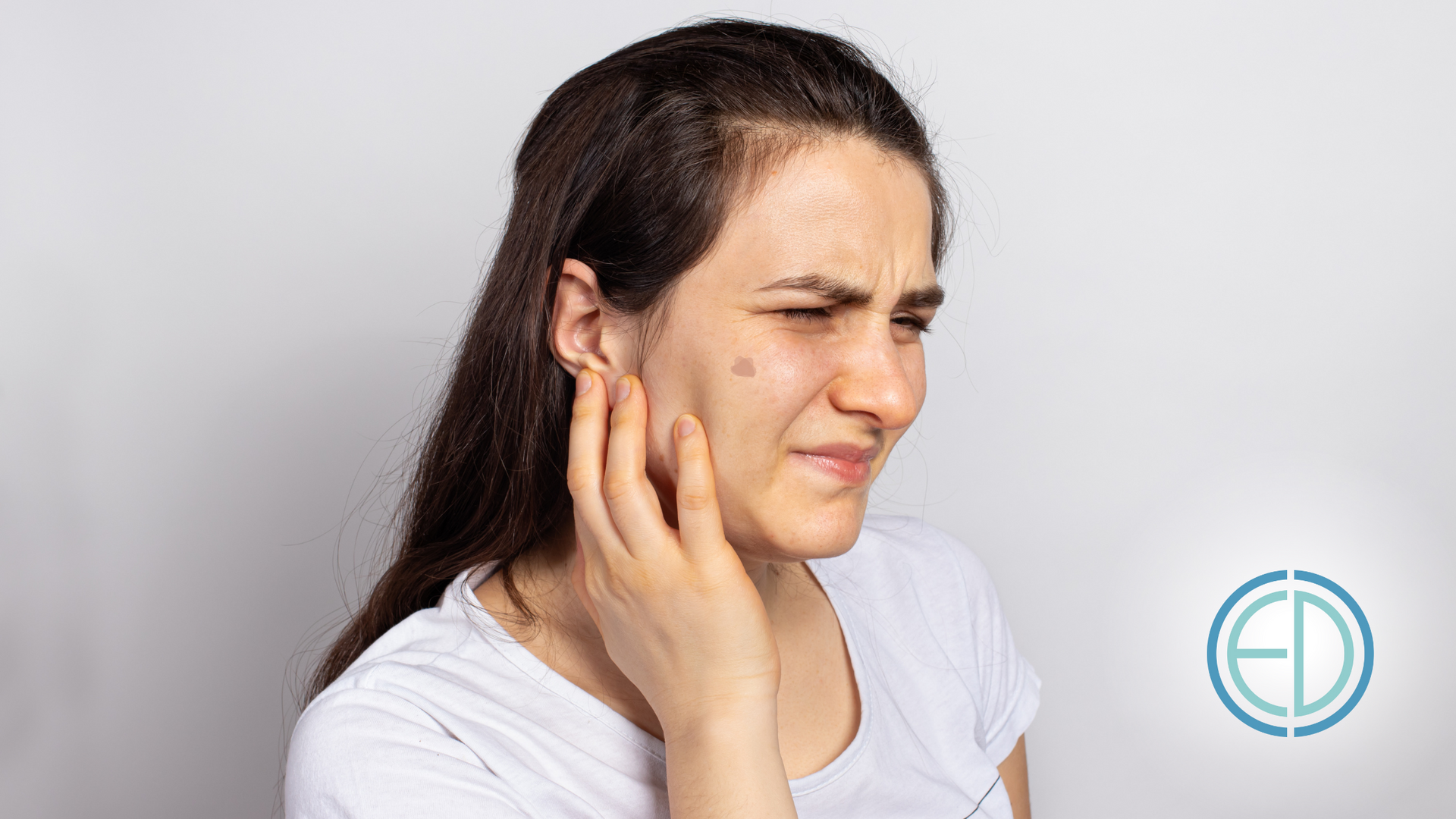 A woman is holding her face in pain because of a toothache.