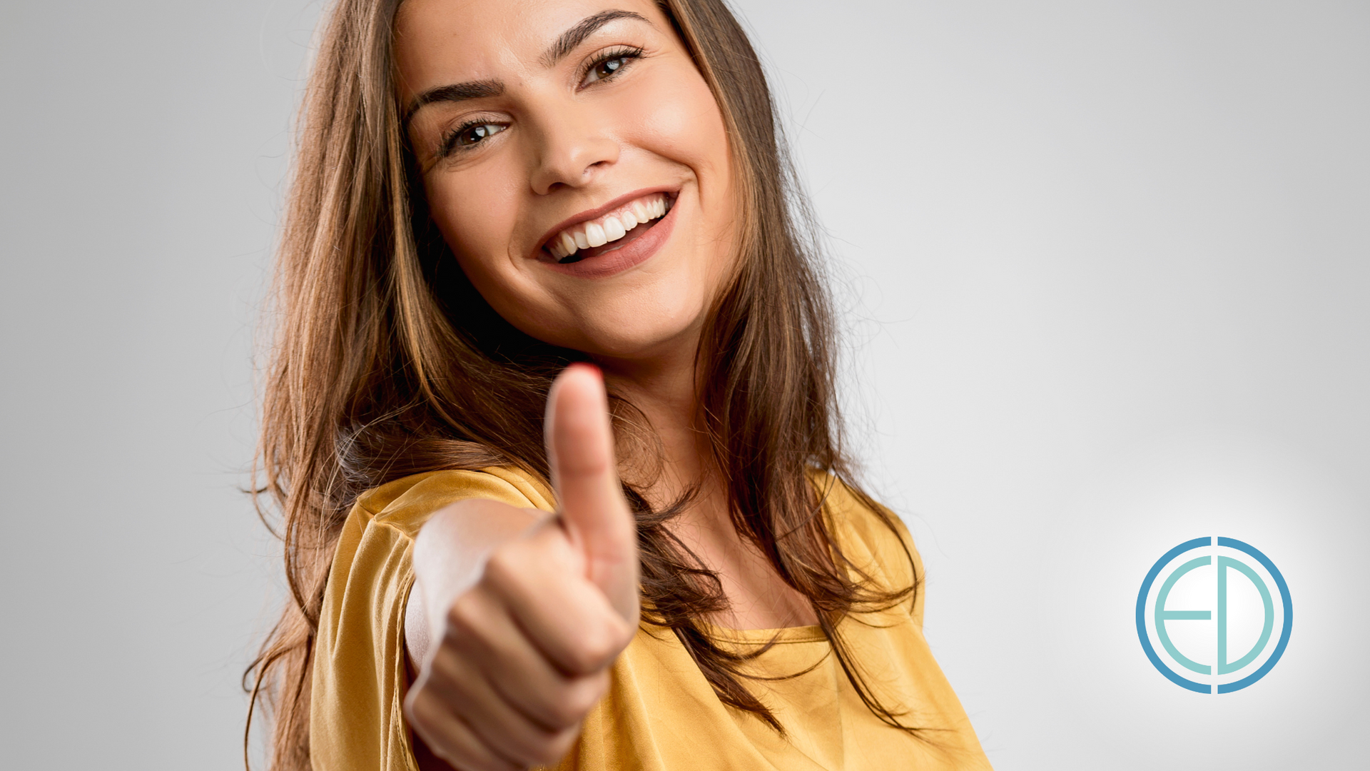 A woman is smiling and giving a thumbs up.