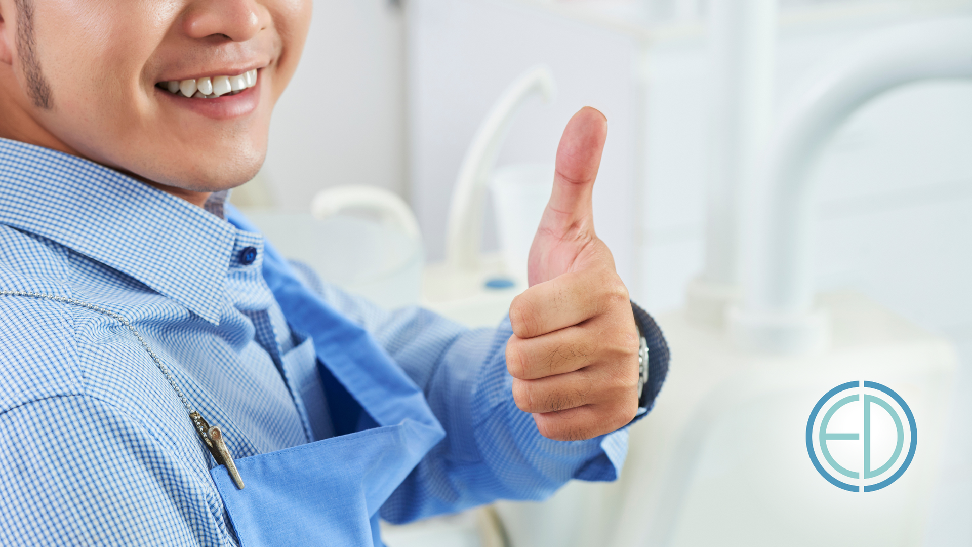A man in a blue shirt is giving a thumbs up.