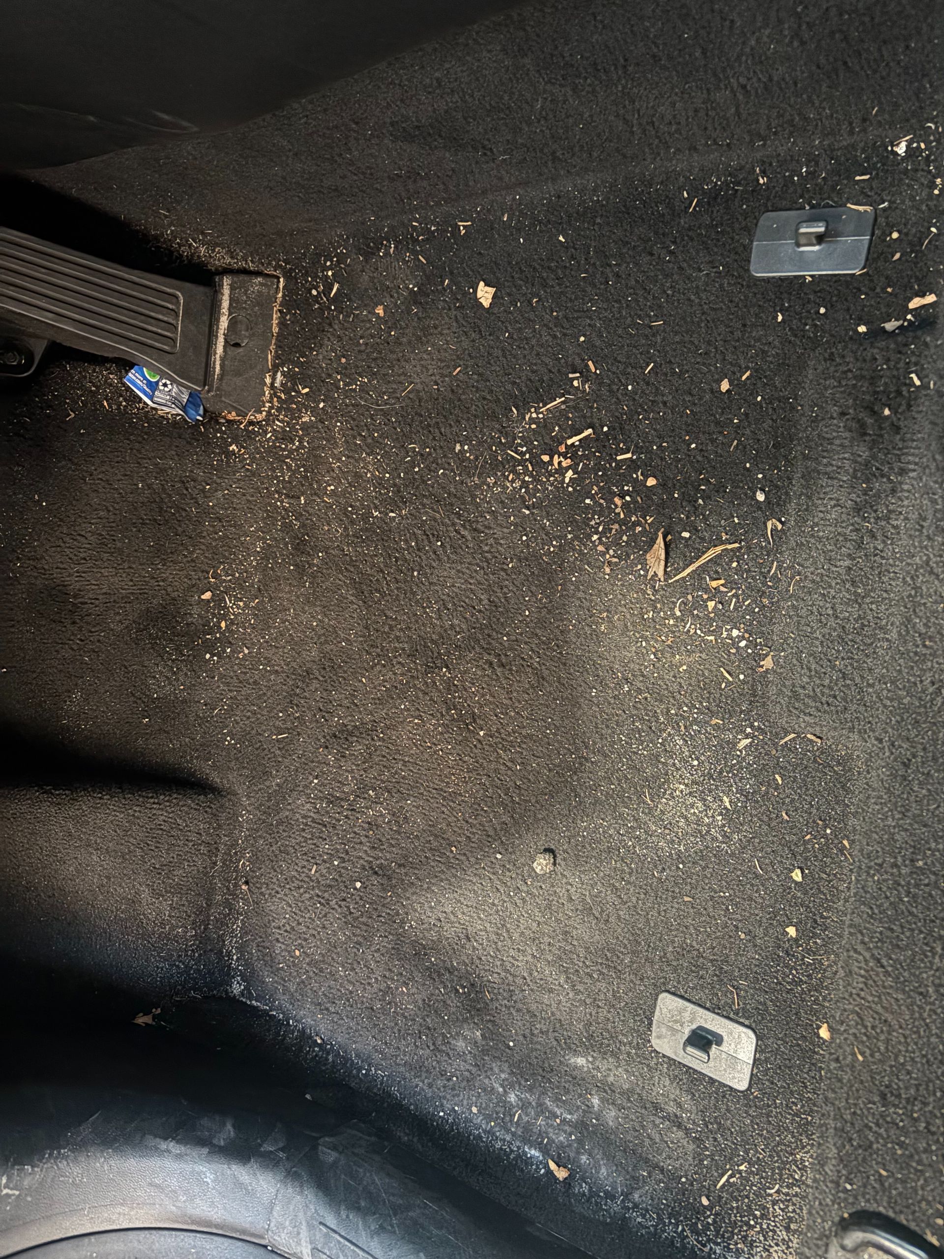 Dirty car carpet interior floor covered in dirt and debris before detailing