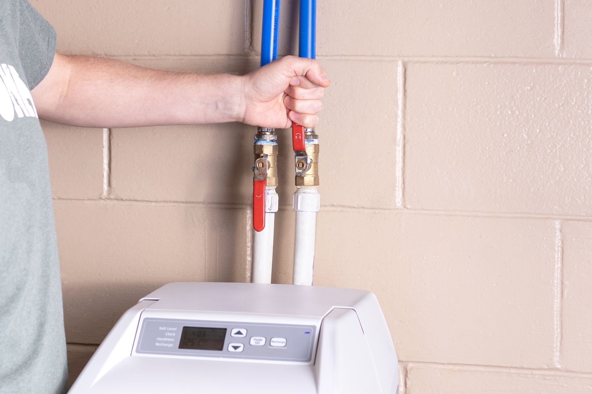 Technician installing water softener with copper fittings and PEX lines. Technician installing water softener with copper fittings and PEX lines.