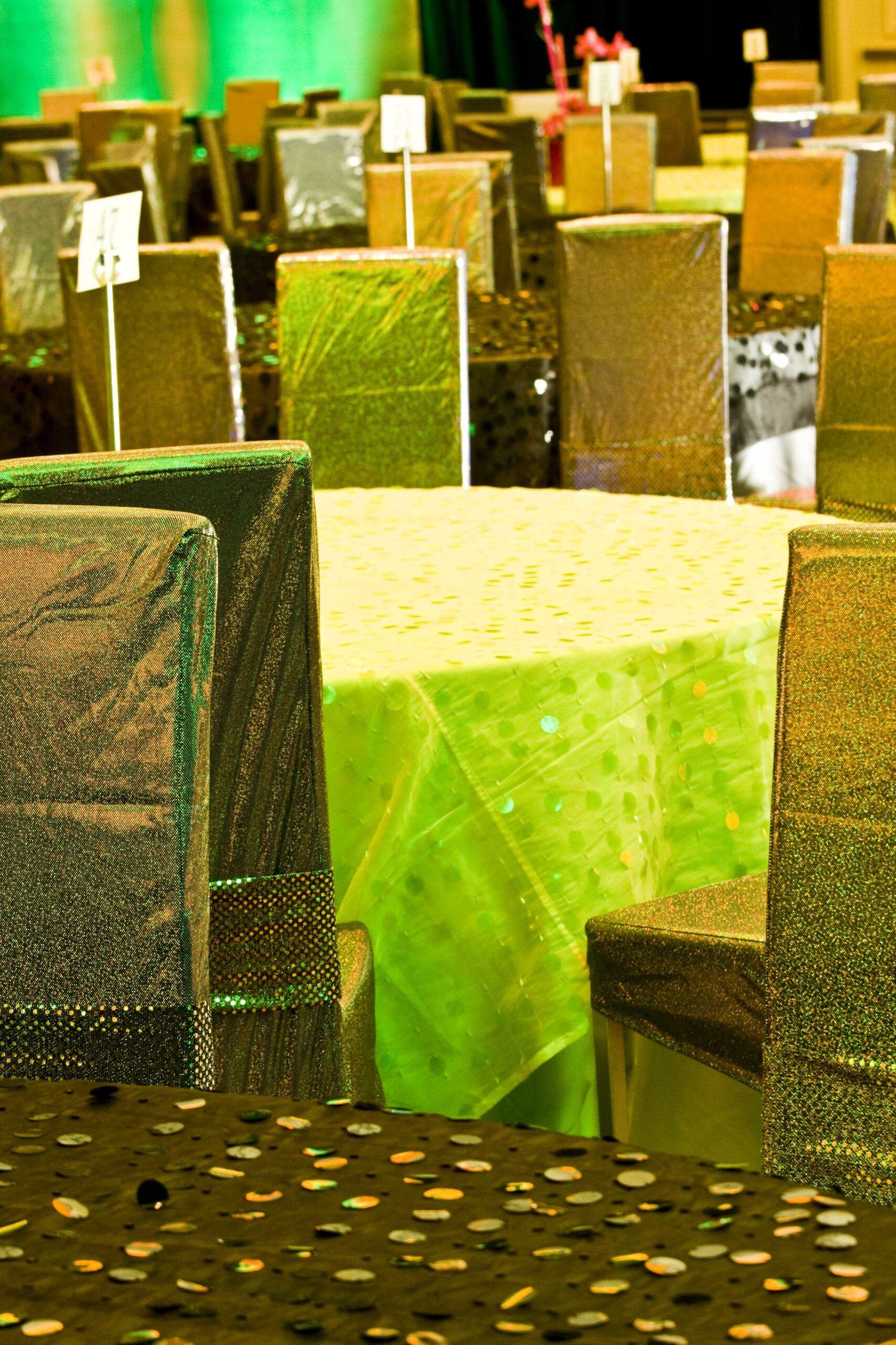 Tables and chairs in a restaurant with green and yellow tablecloths and dotted seats — commercial advertising photography