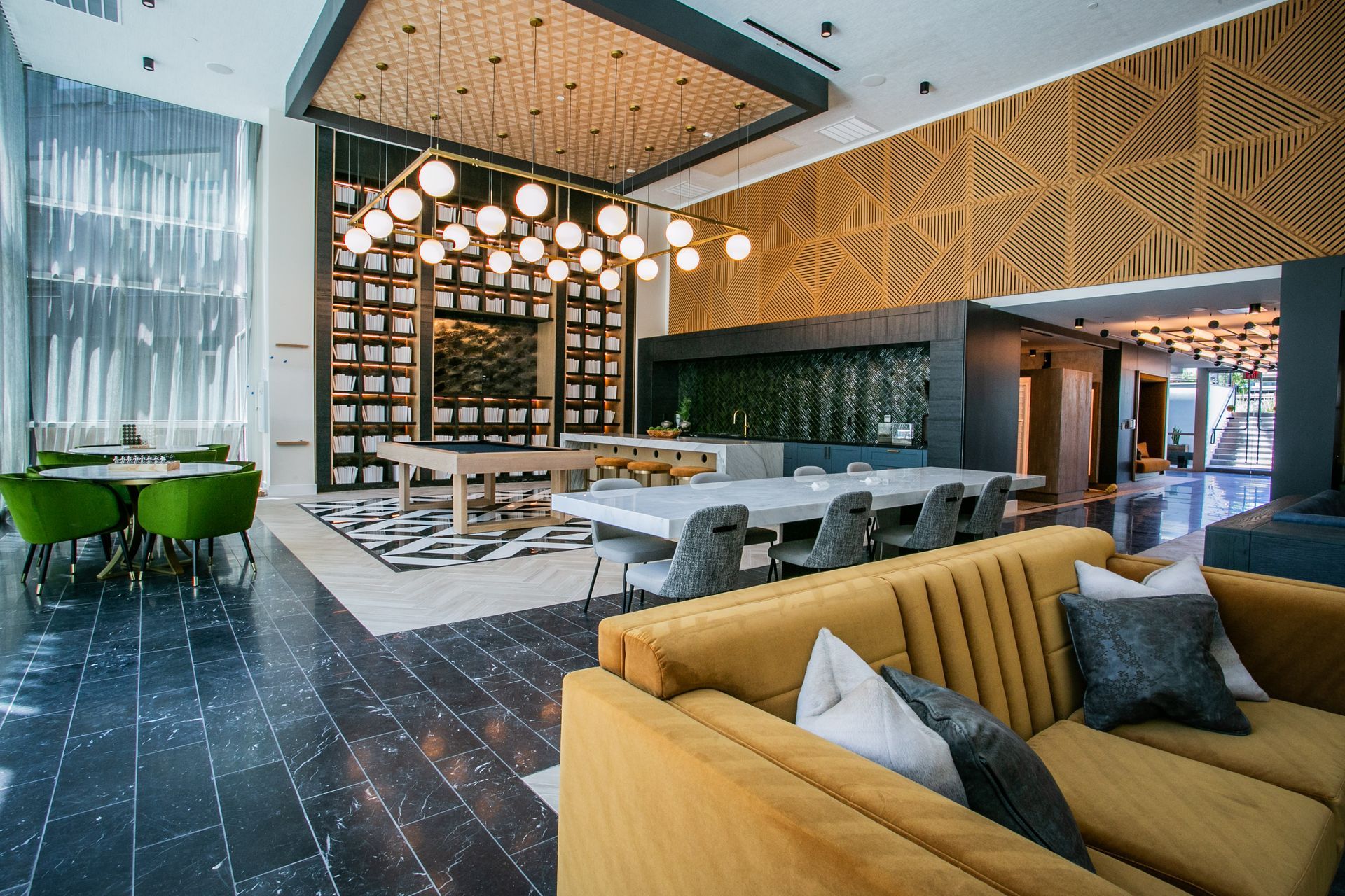 Modern hotel lounge with mustard sofas, gray seating, pendant lights — multi-family photography