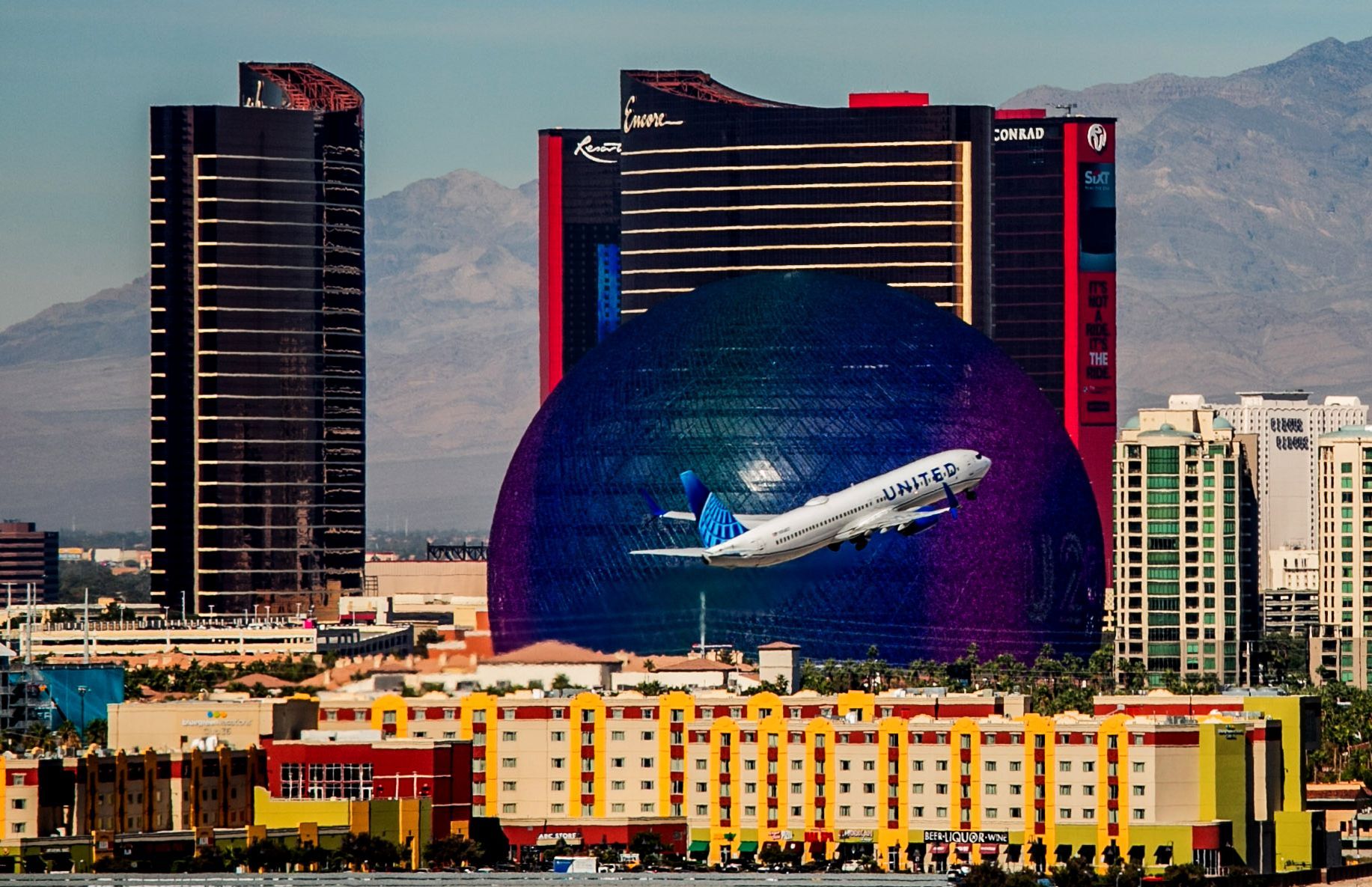 City skyline with a giant blue globe mural and a jet plane — Las Vegas multi-family photography