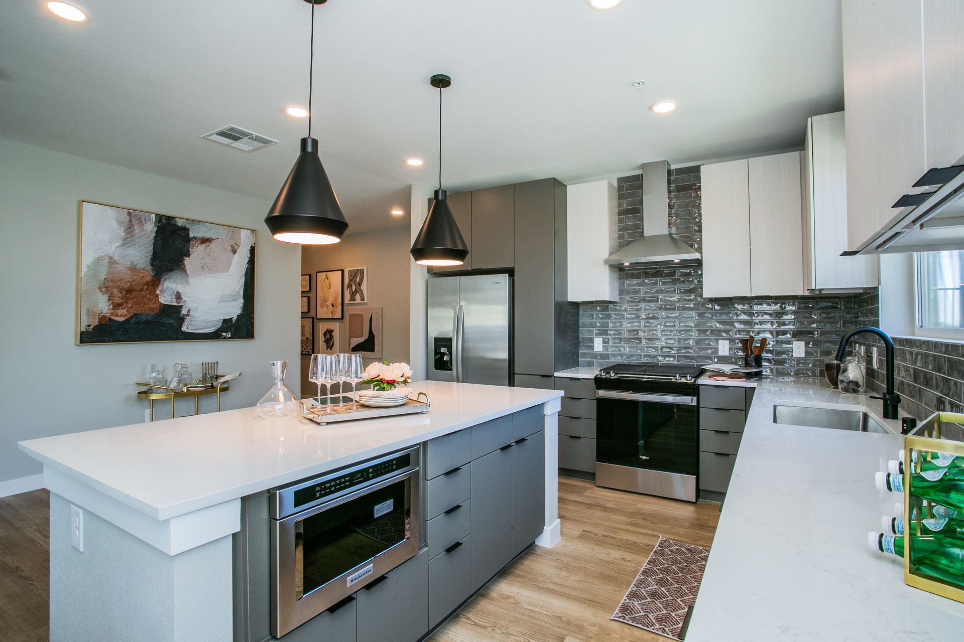 Modern kitchen with gray cabinets, central island, pendant lights — Las Vegas photography