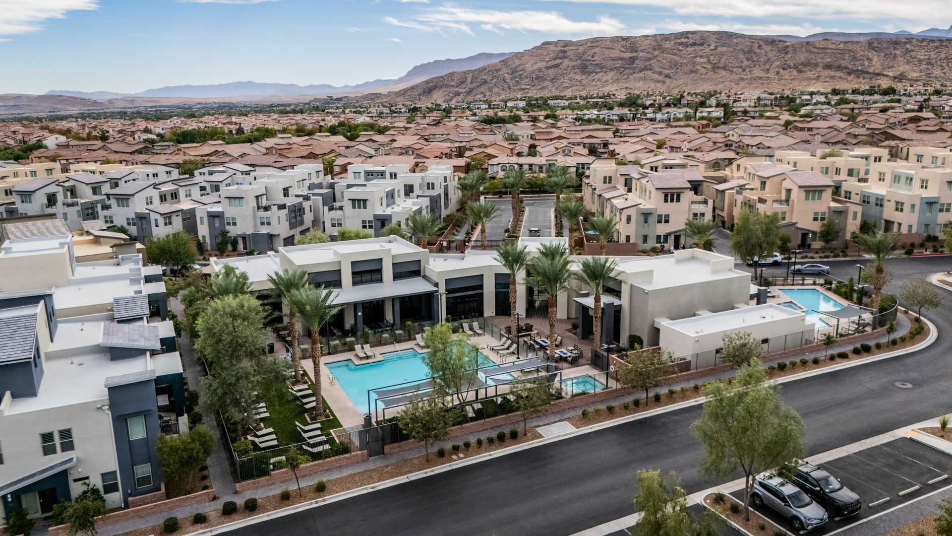 Modern apartment complex with a pool, palm trees, and desert hills in the background — Las Vegas real estate photography