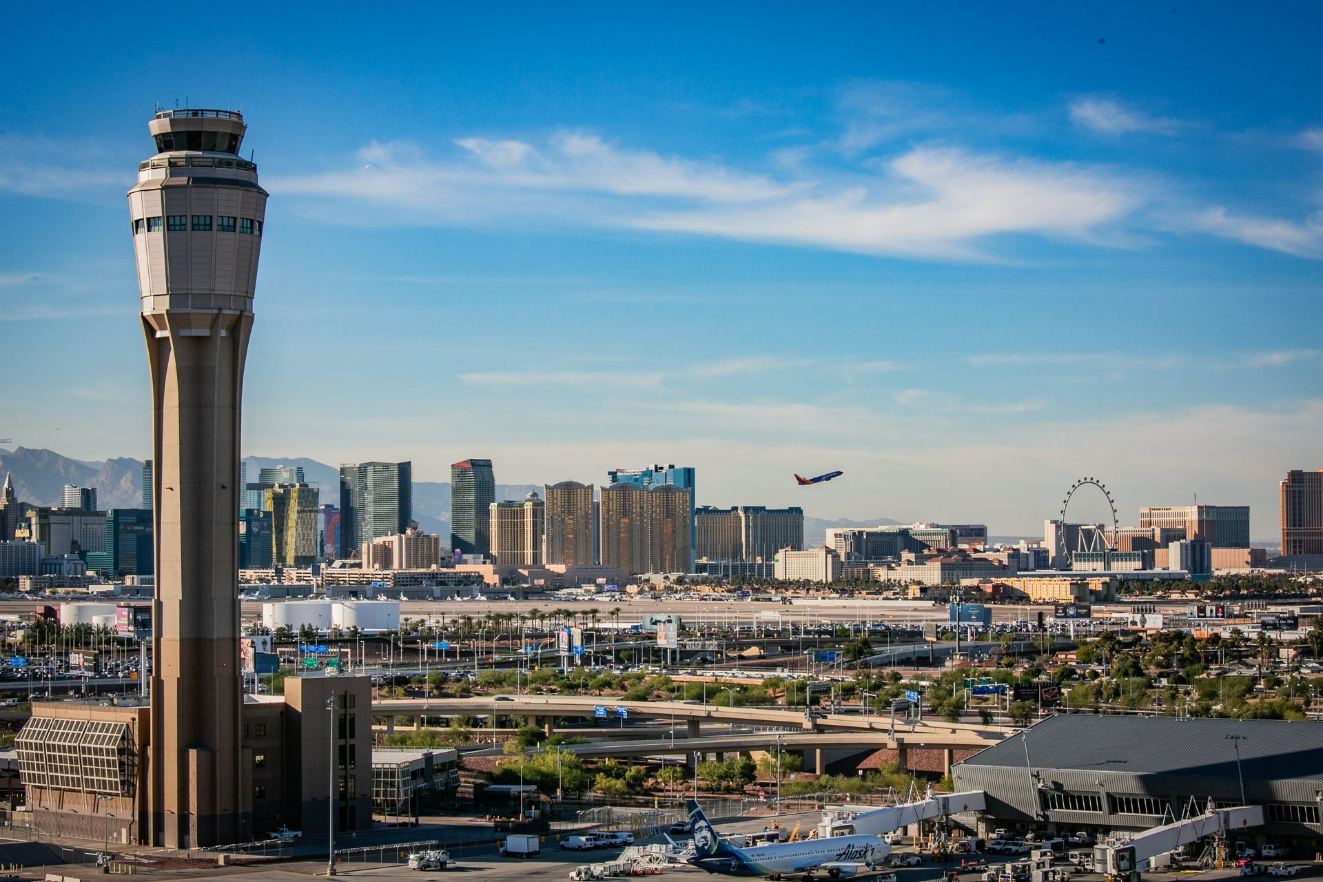 Airport control tower overlooking a city skyline under a blue sky — multi-family photography