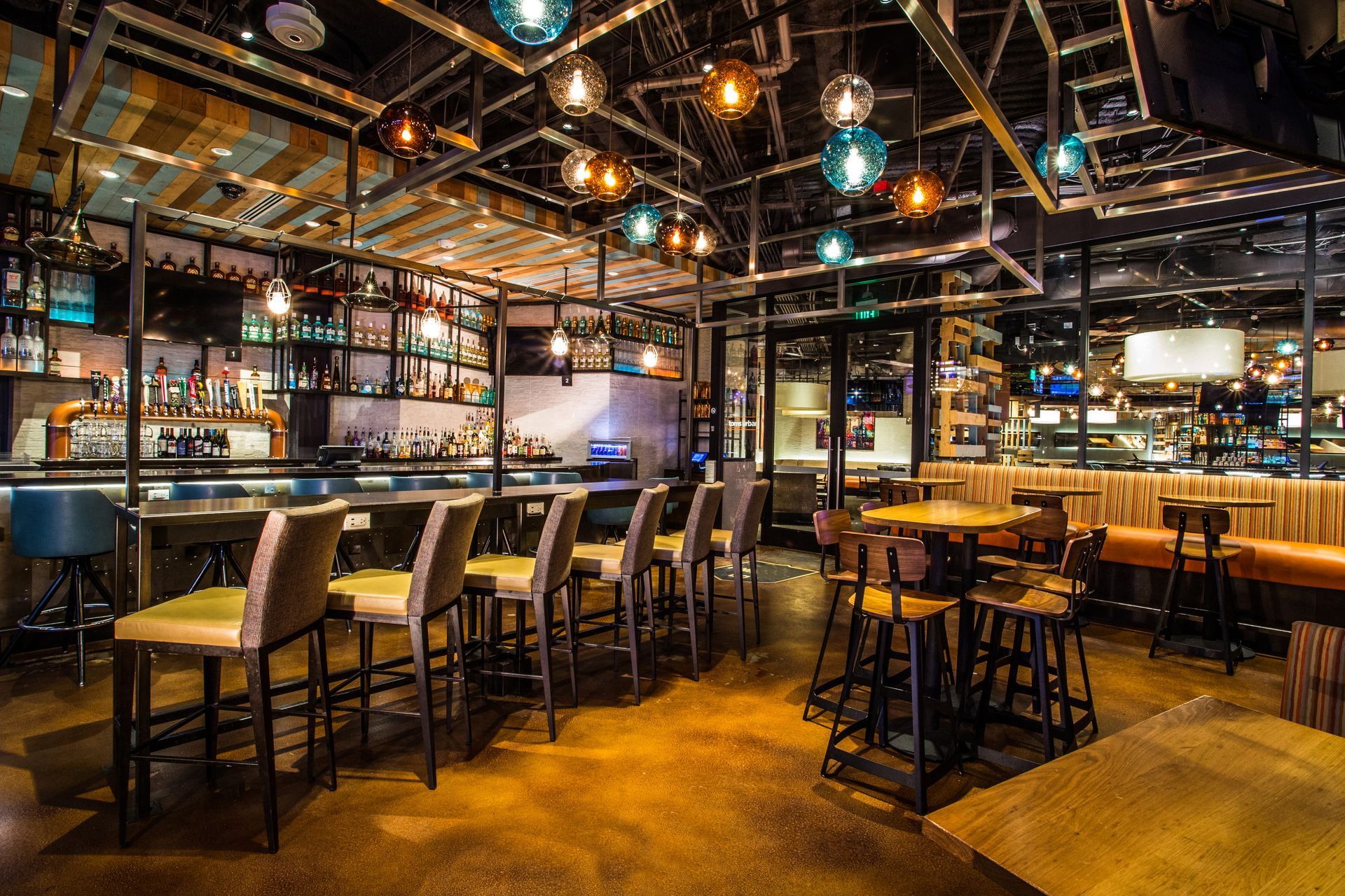 Warmly lit modern bar and restaurant interior with high tables, stools, and hanging lights — Las Vegas commercial multi-family property photography