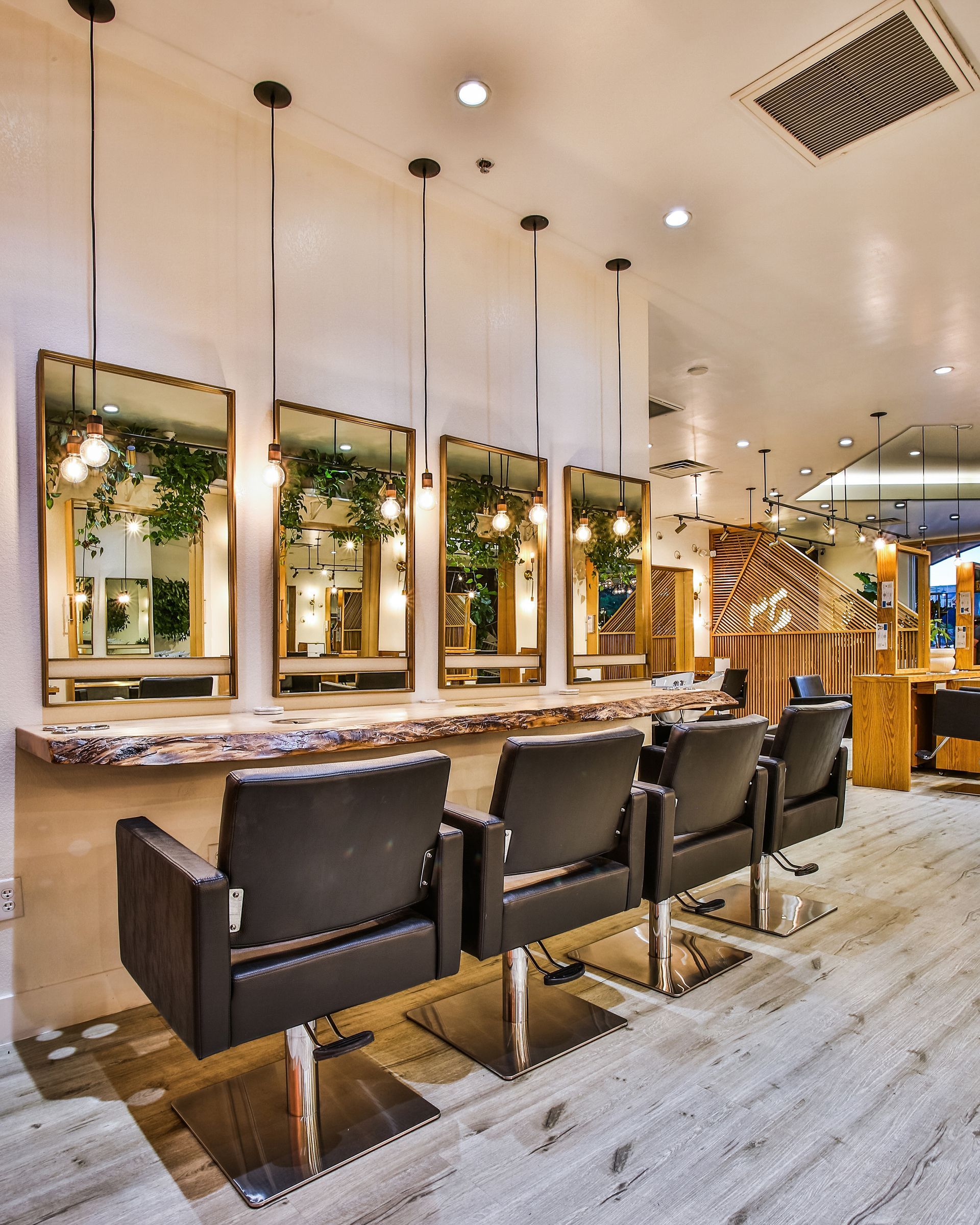Modern salon interior with mirrored styling stations, black chairs — multi-family photography