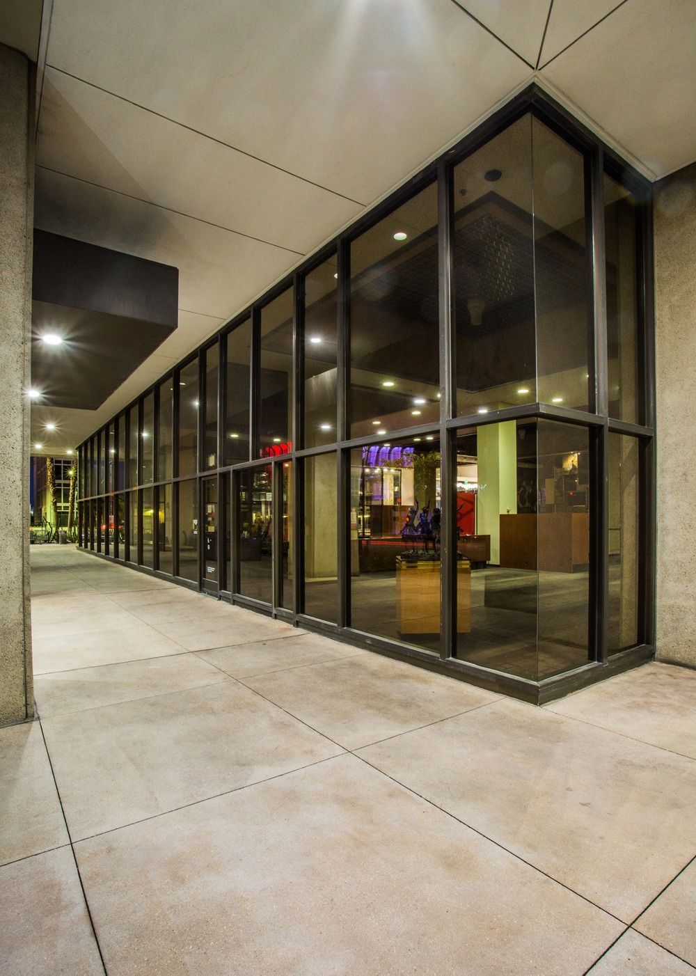 Glass storefront entrance along a covered sidewalk at night — Las Vegas architecture photography