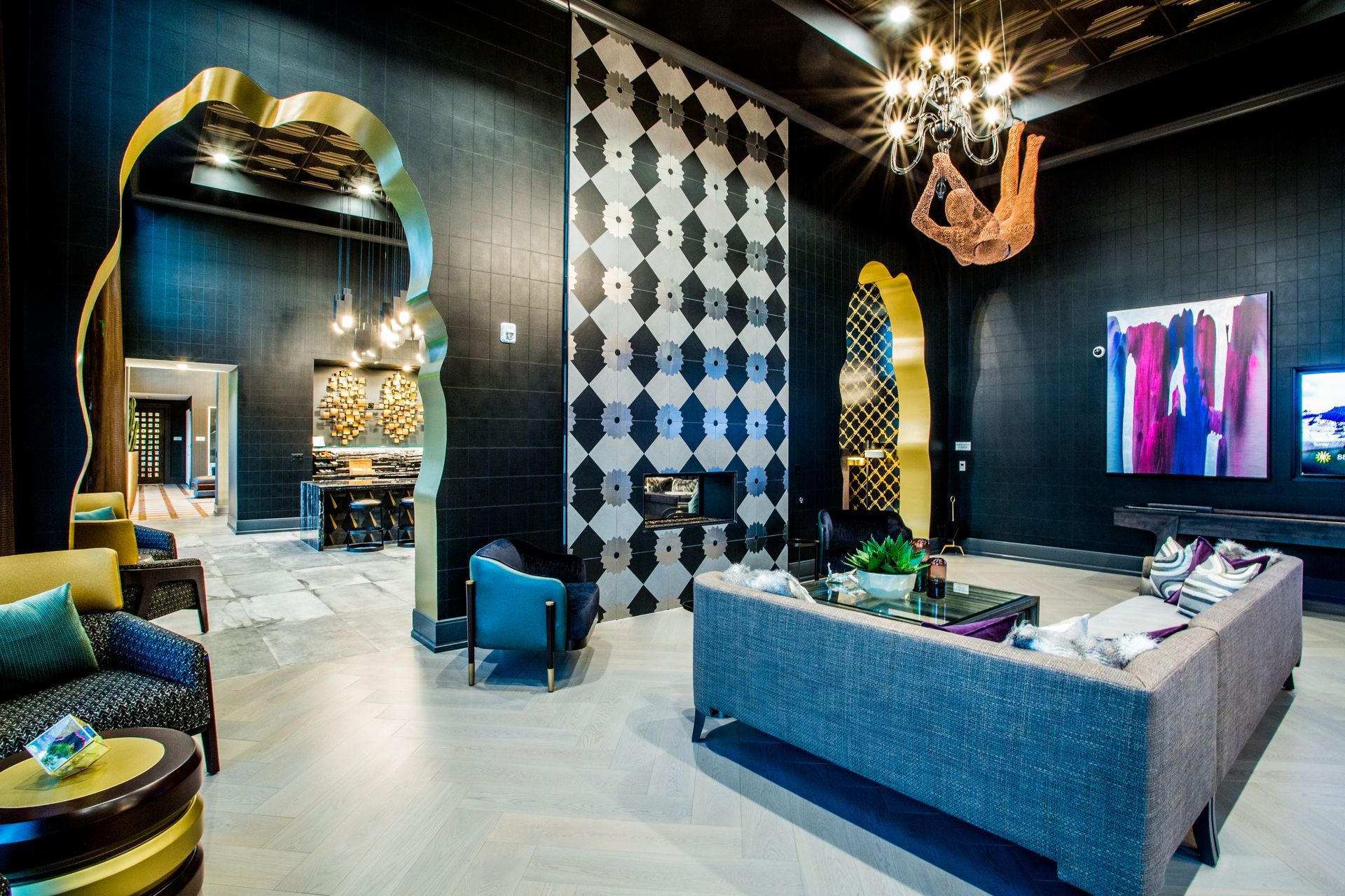 Stylish black-and-white lounge with patterned walls, blue chairs — multi-family photography