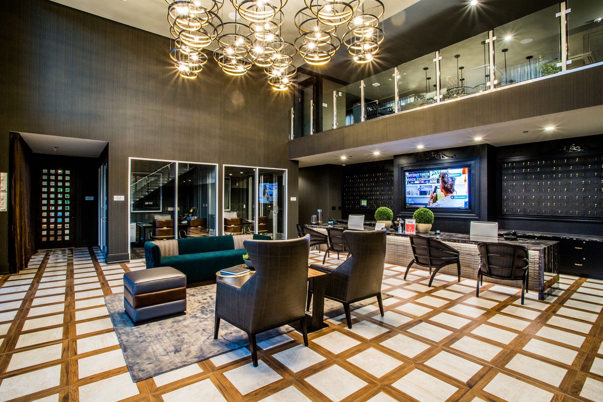 Modern hotel lobby with chandeliers, patterned tile floor, sofas — multi-family photography