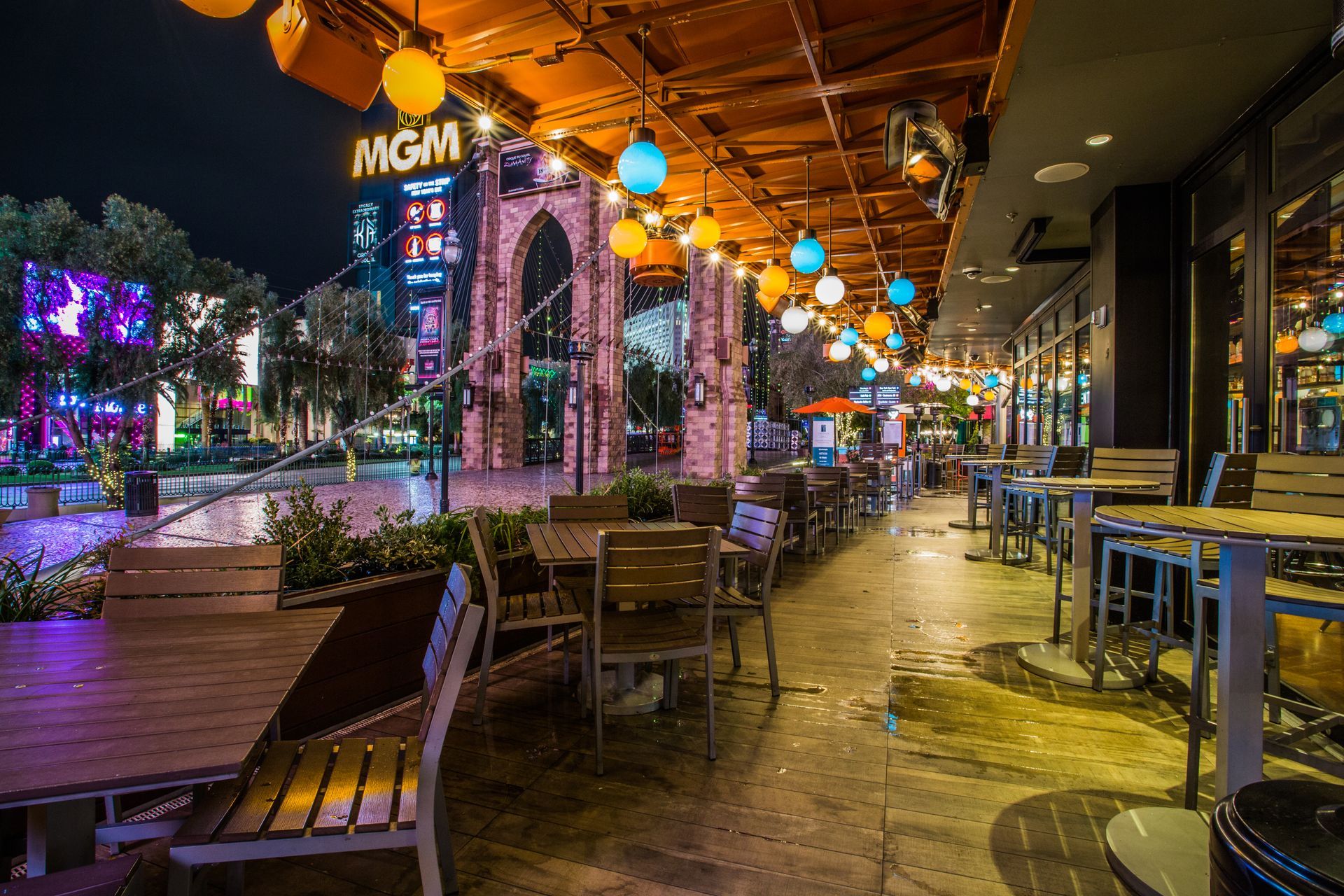 Colorful outdoor restaurant patio at night with string lights and an MGM — multi-family photography