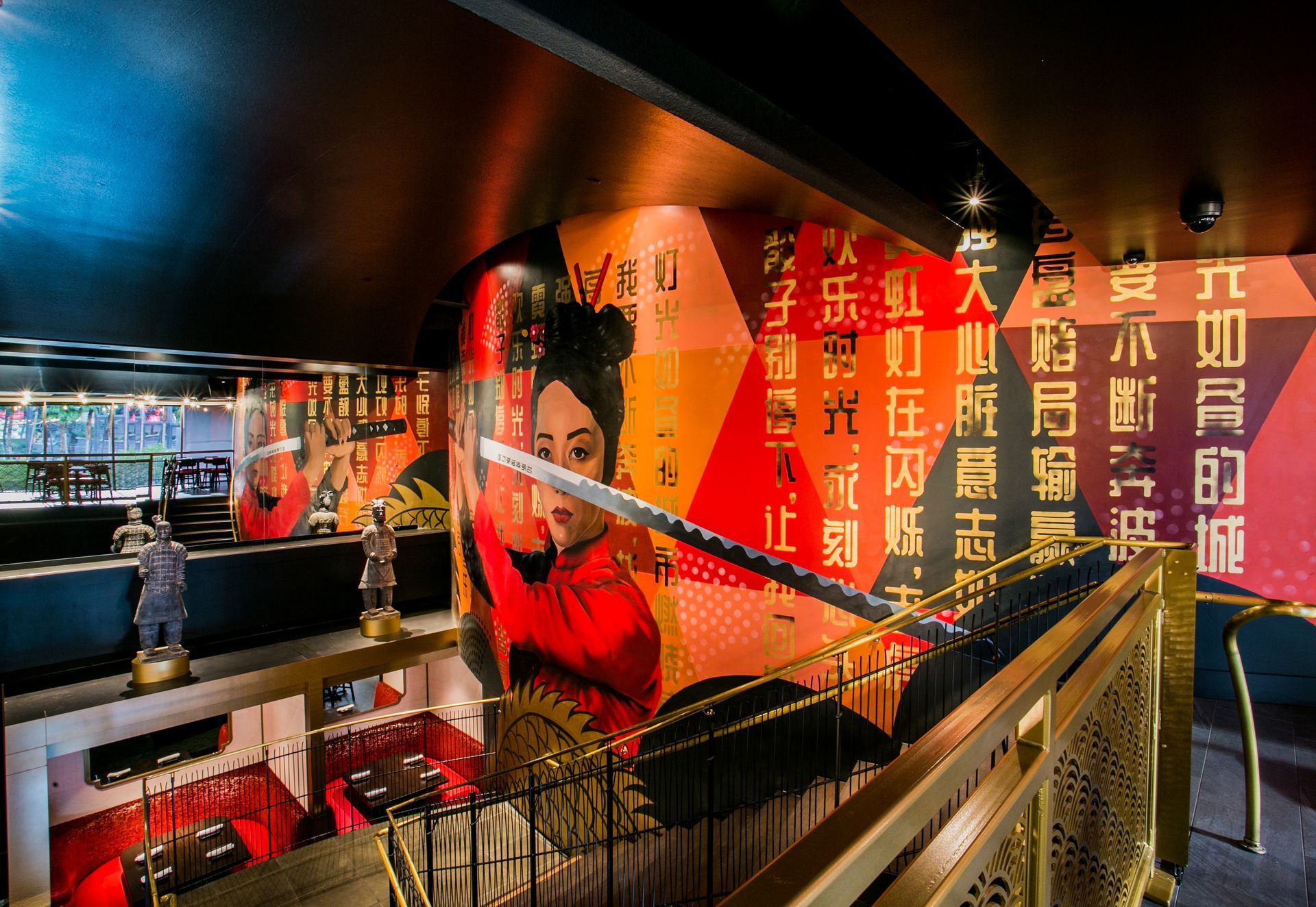 Colorful indoor mural with a large face and Chinese text beside a railing in a modern exhibit space — commercial multi-family property photography