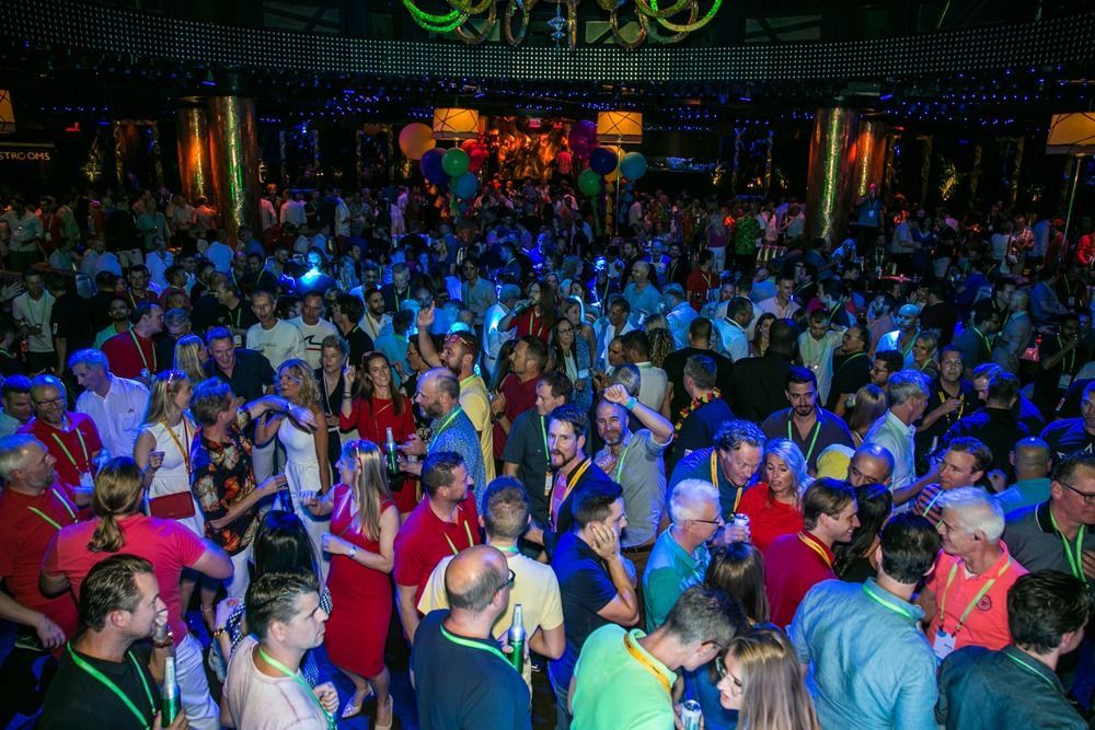 Crowded nightclub dance floor with colorful lighting and people dancing under a disco ball