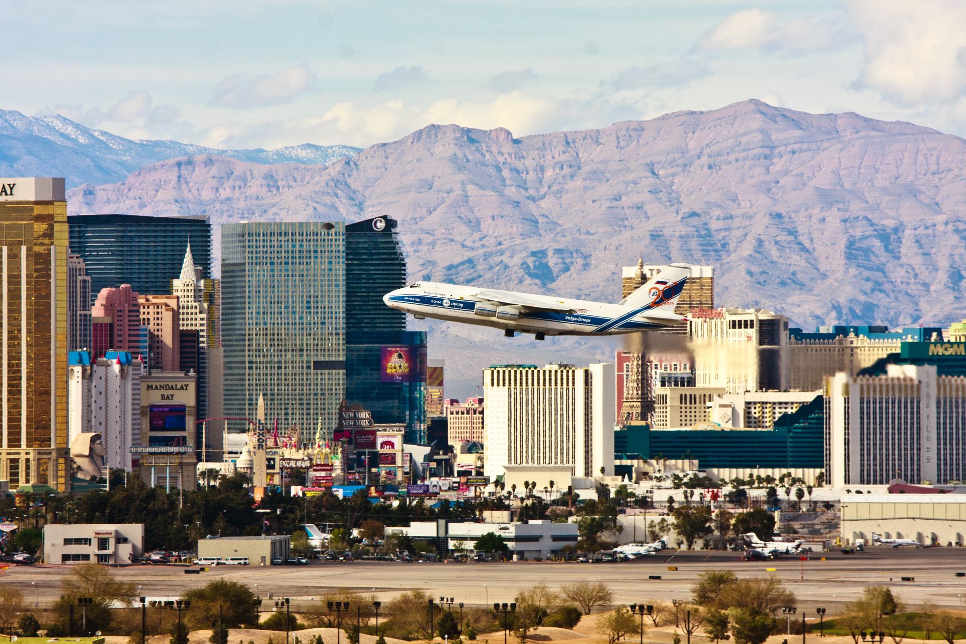 Airplane landing over Las Vegas skyline with desert mountains in the background