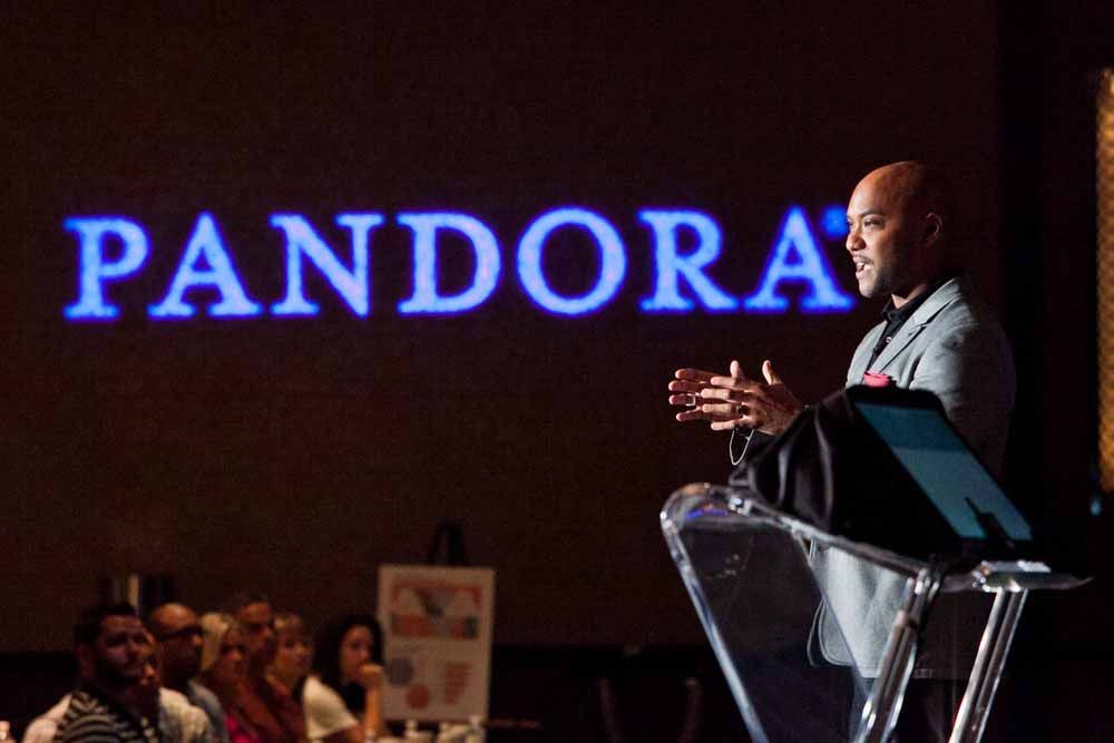 Speaker at podium beside glowing PANDORA sign — Las Vegas advertising photography