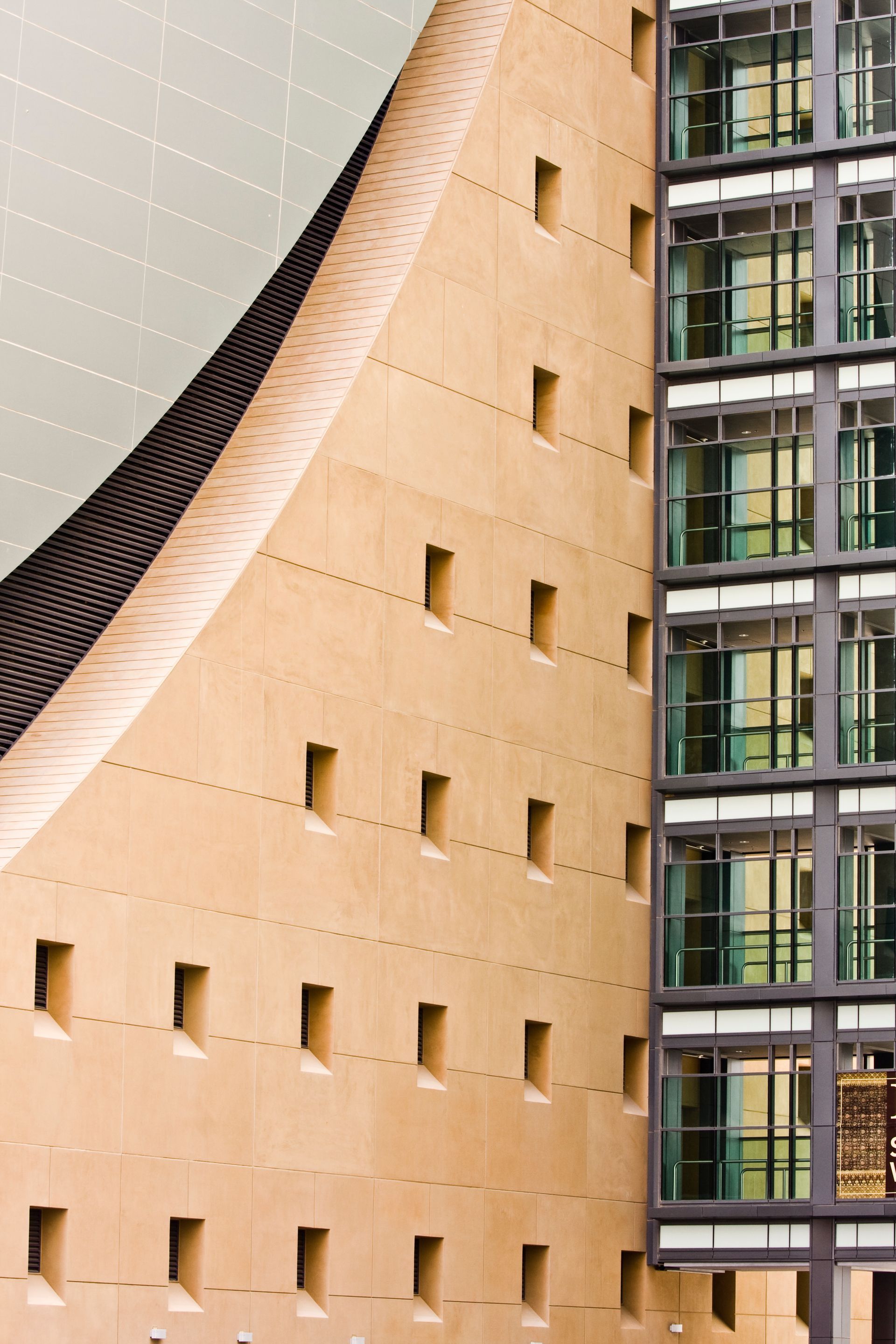 Curved tan building facade beside a modern glass office tower — Las Vegas architectural photography