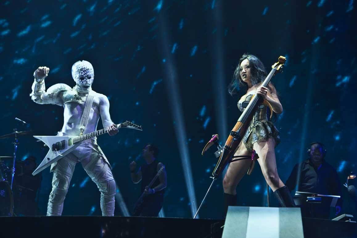 Two musicians performing on a dark blue-lit stage — event photography