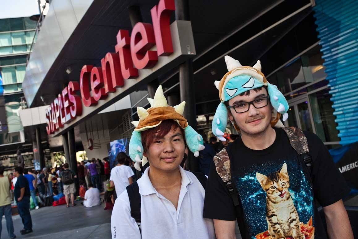 Two people in colorful costumes stand outside a Staples Center entrance — Las Vegas convention and event photography