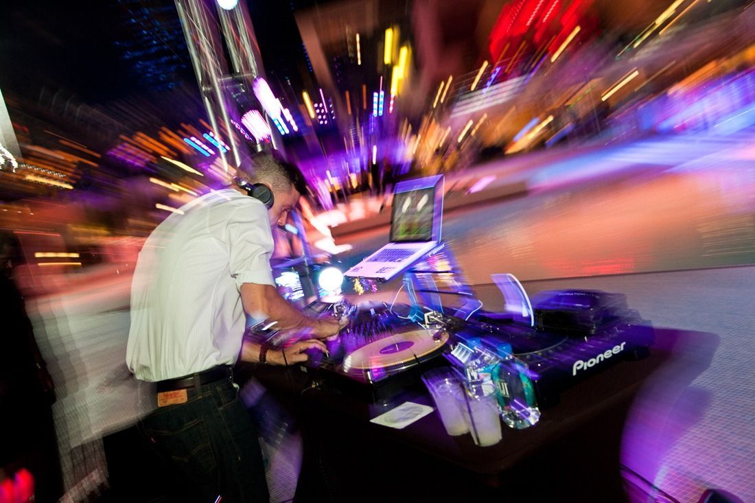 DJ mixing music at a neon-lit nightclub — event photography