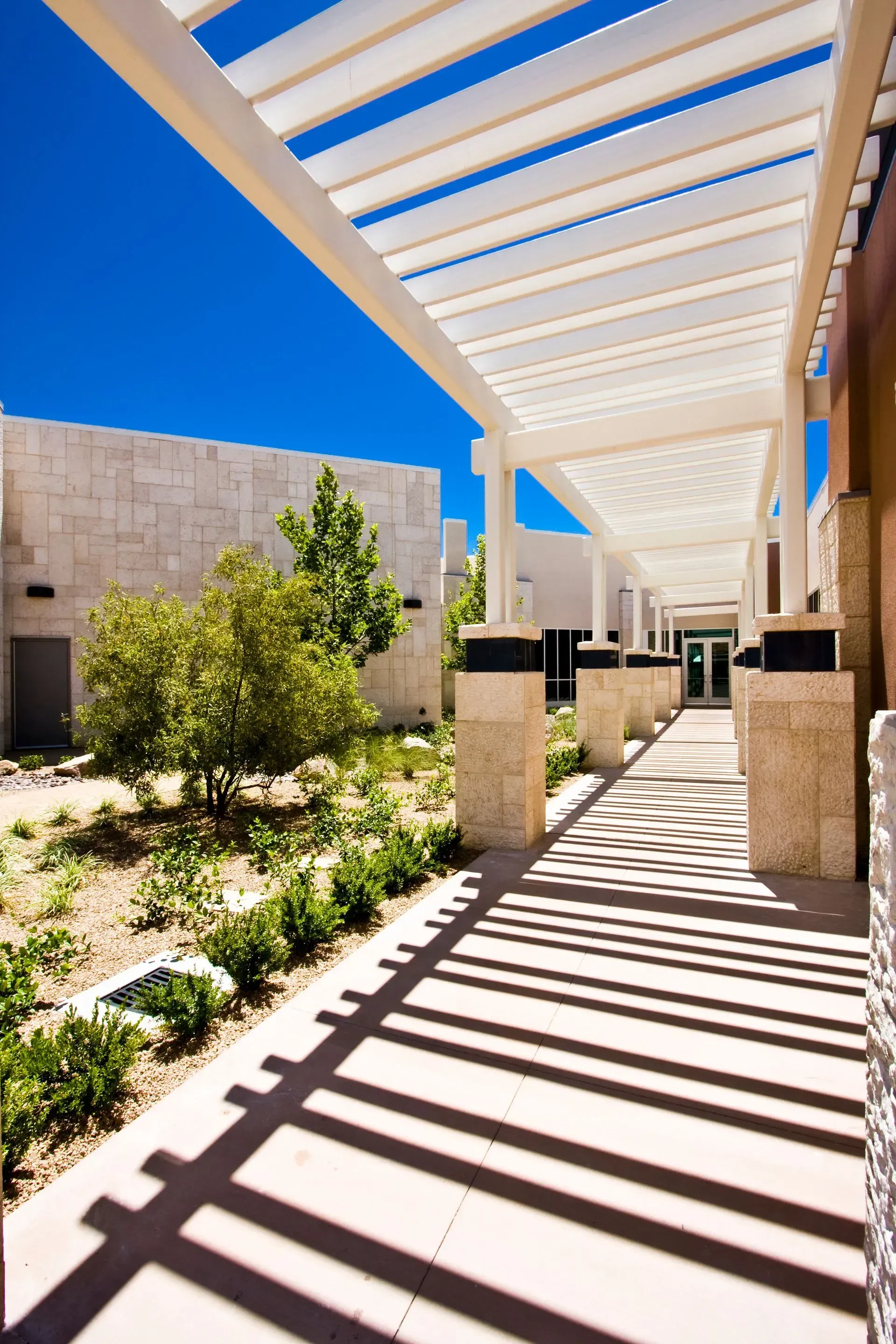 Covered walkway with white slats casting striped shadows beside desert — Las Vegas photography