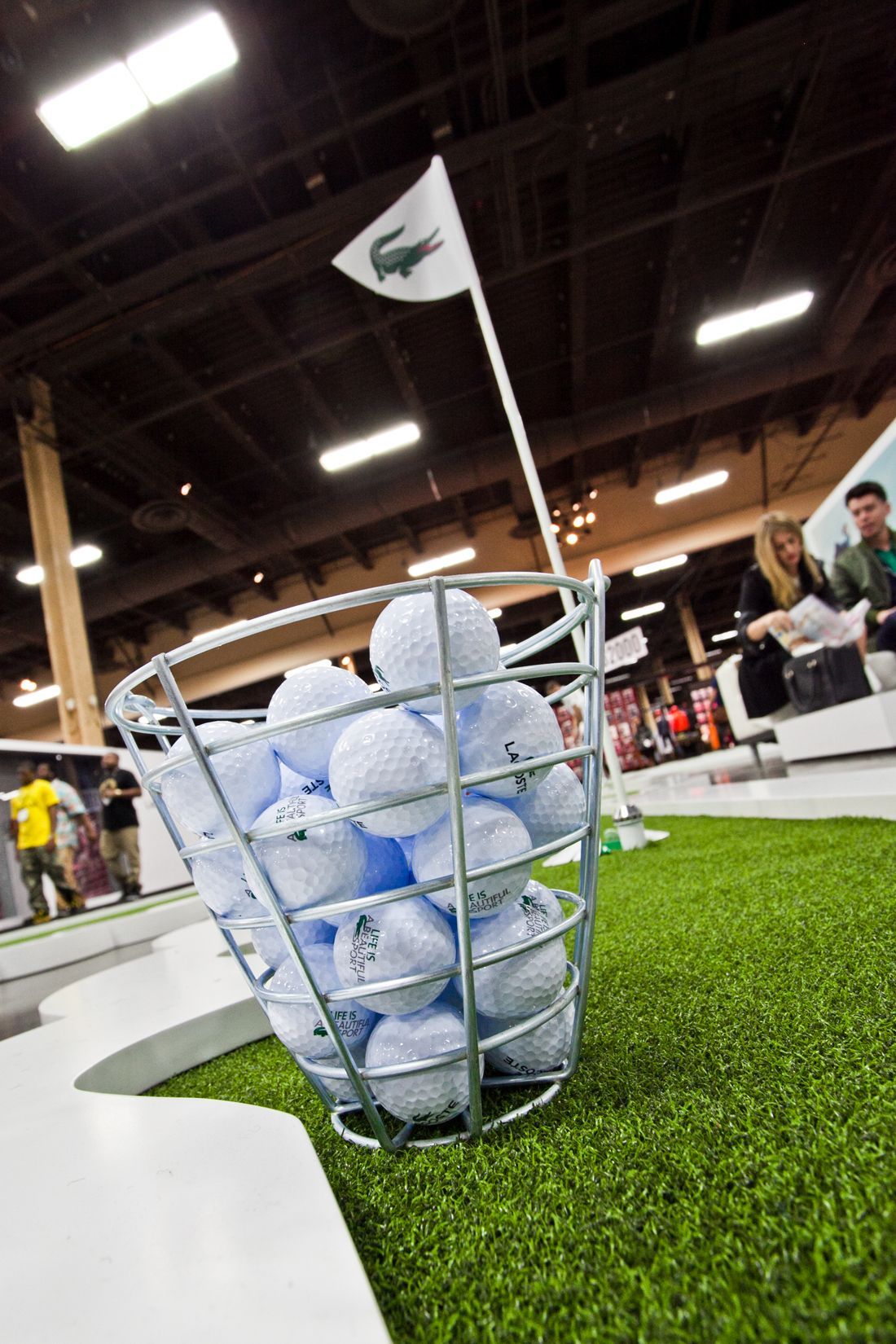 Wire basket filled with golf balls on indoor putting green — event photography