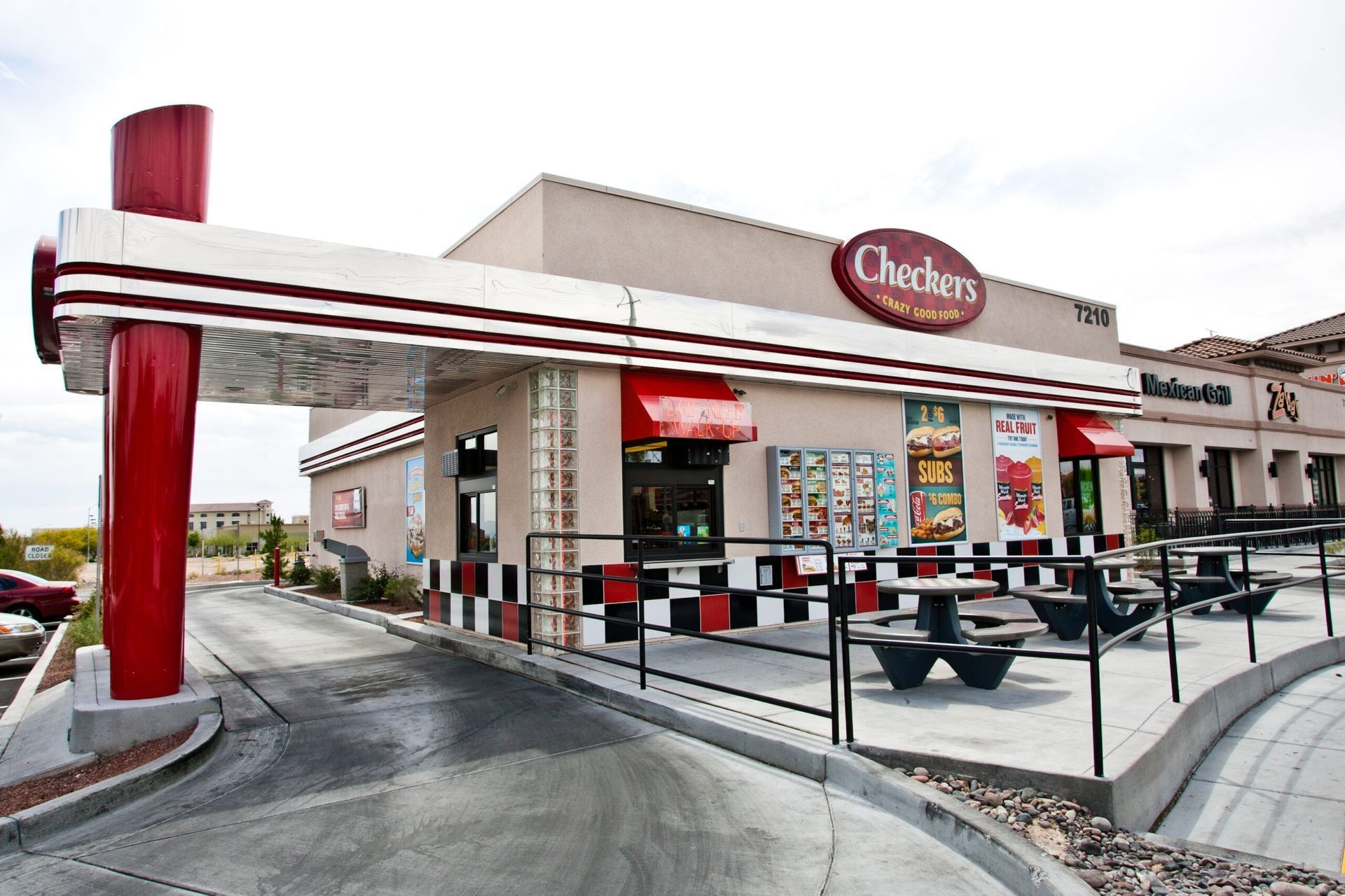 Checkers fast-food restaurant exterior with red-and-white awning and outdoor seating
