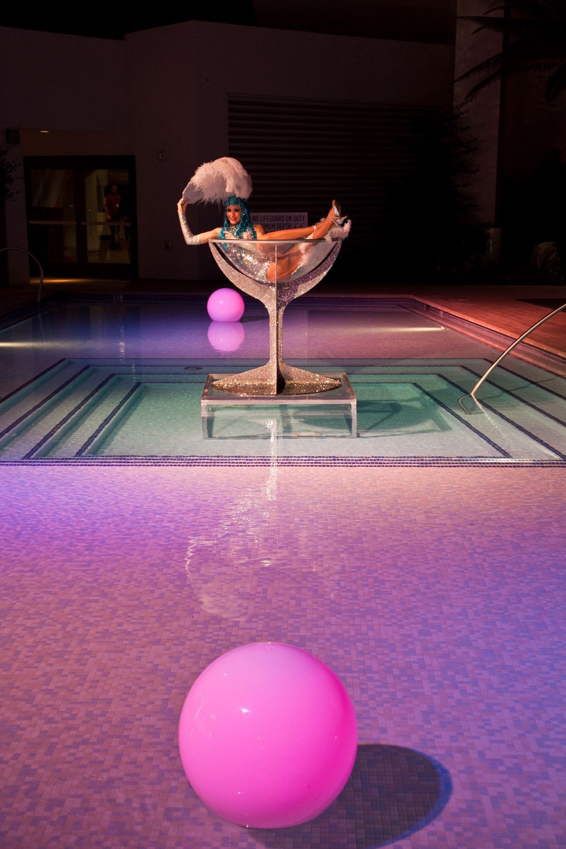 Pink balls near a glass trophy on a lit tiled surface at night — Las Vegas convention and event photography