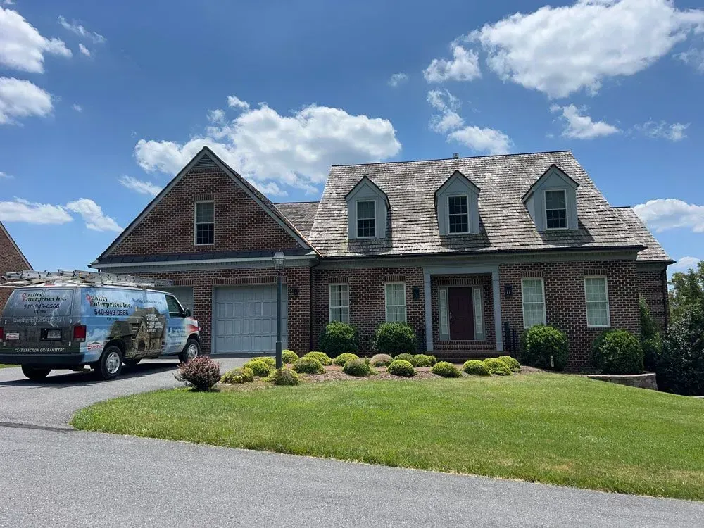A large brick house with a van parked in front of it.