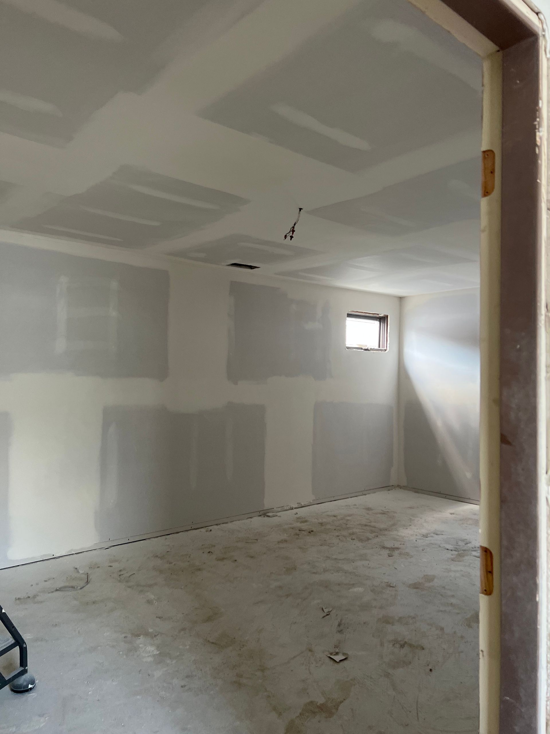 An empty room with drywall on the walls and a window