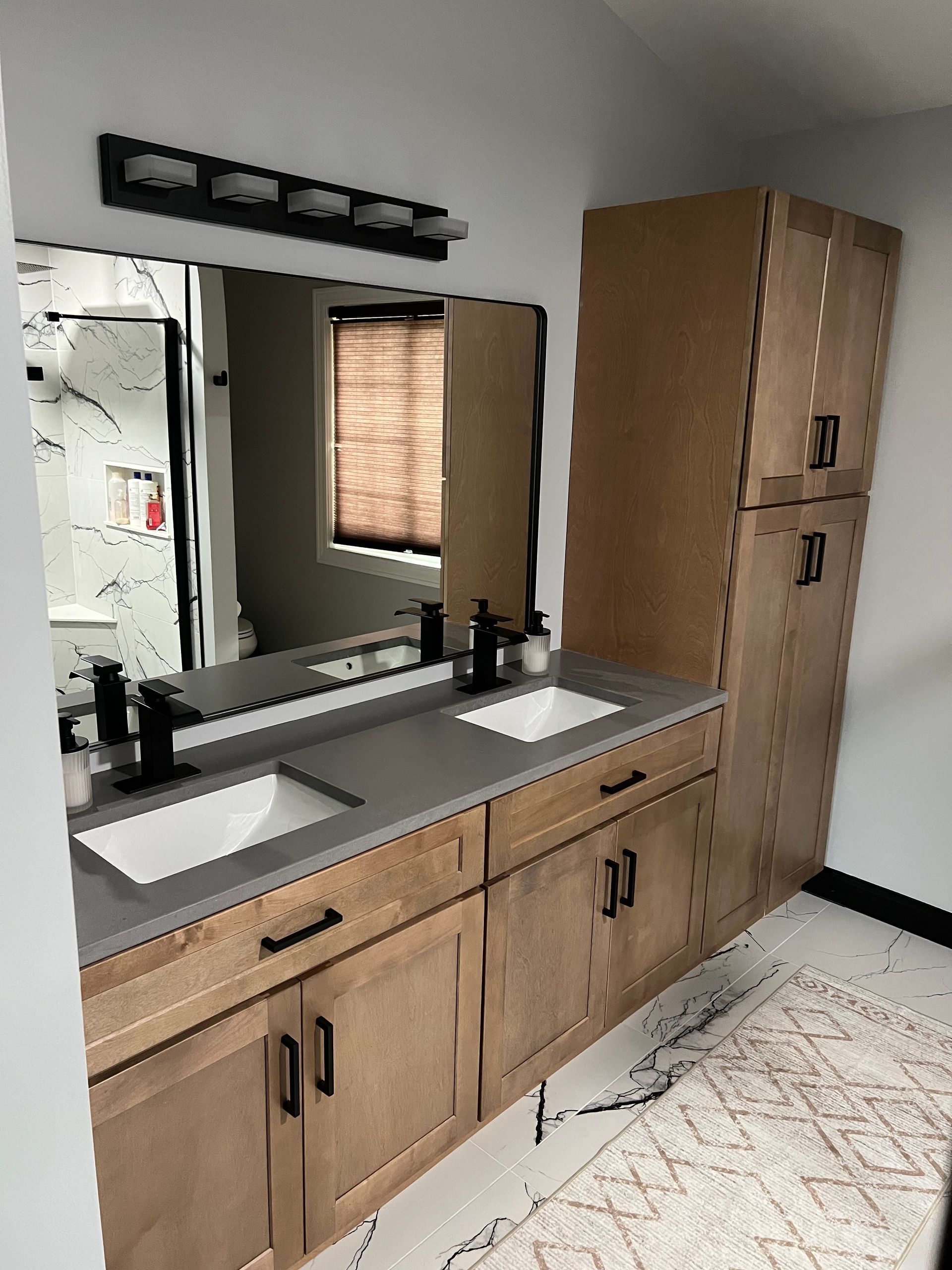 A bathroom with two sinks and a large mirror.