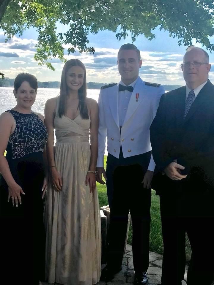 A group of people standing next to each other in front of a body of water.