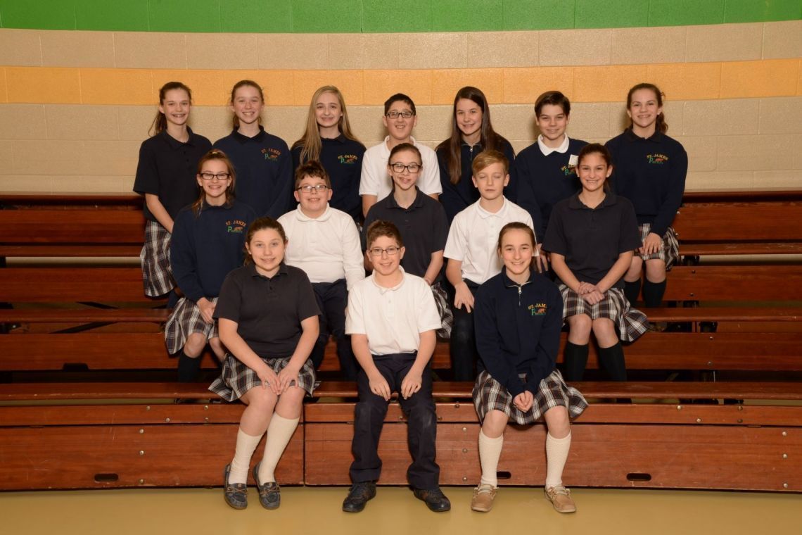 A group of children in school uniforms pose for a picture