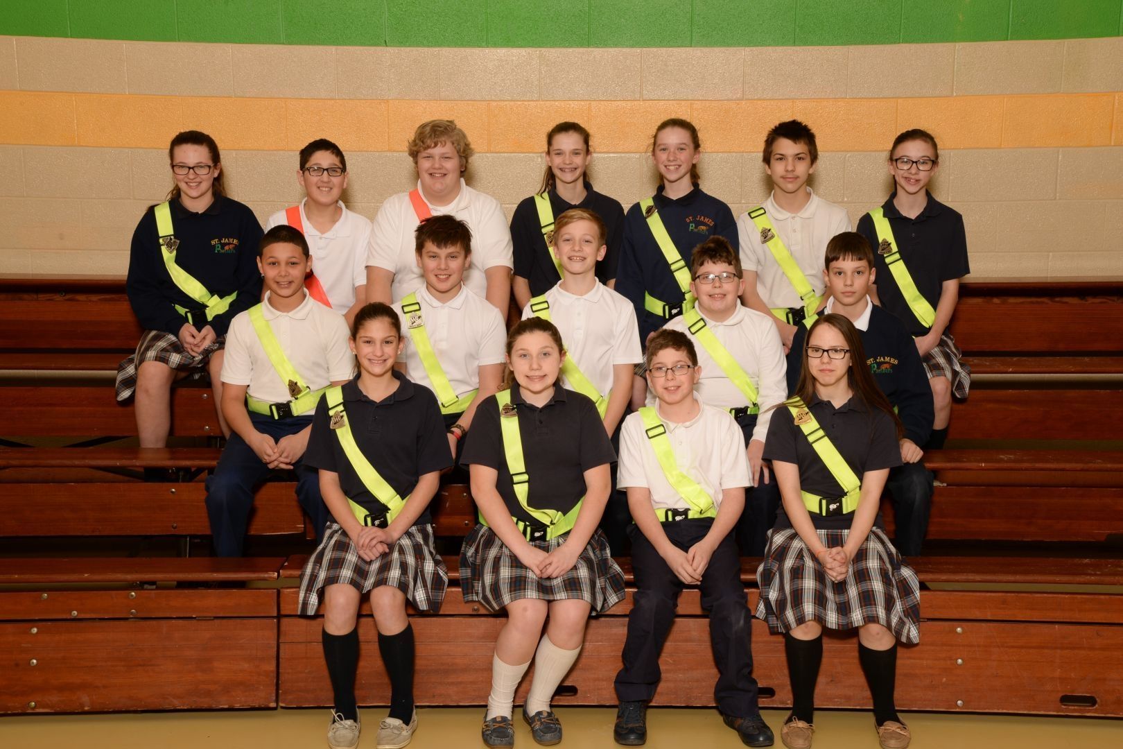 A group of children wearing yellow sashes pose for a picture