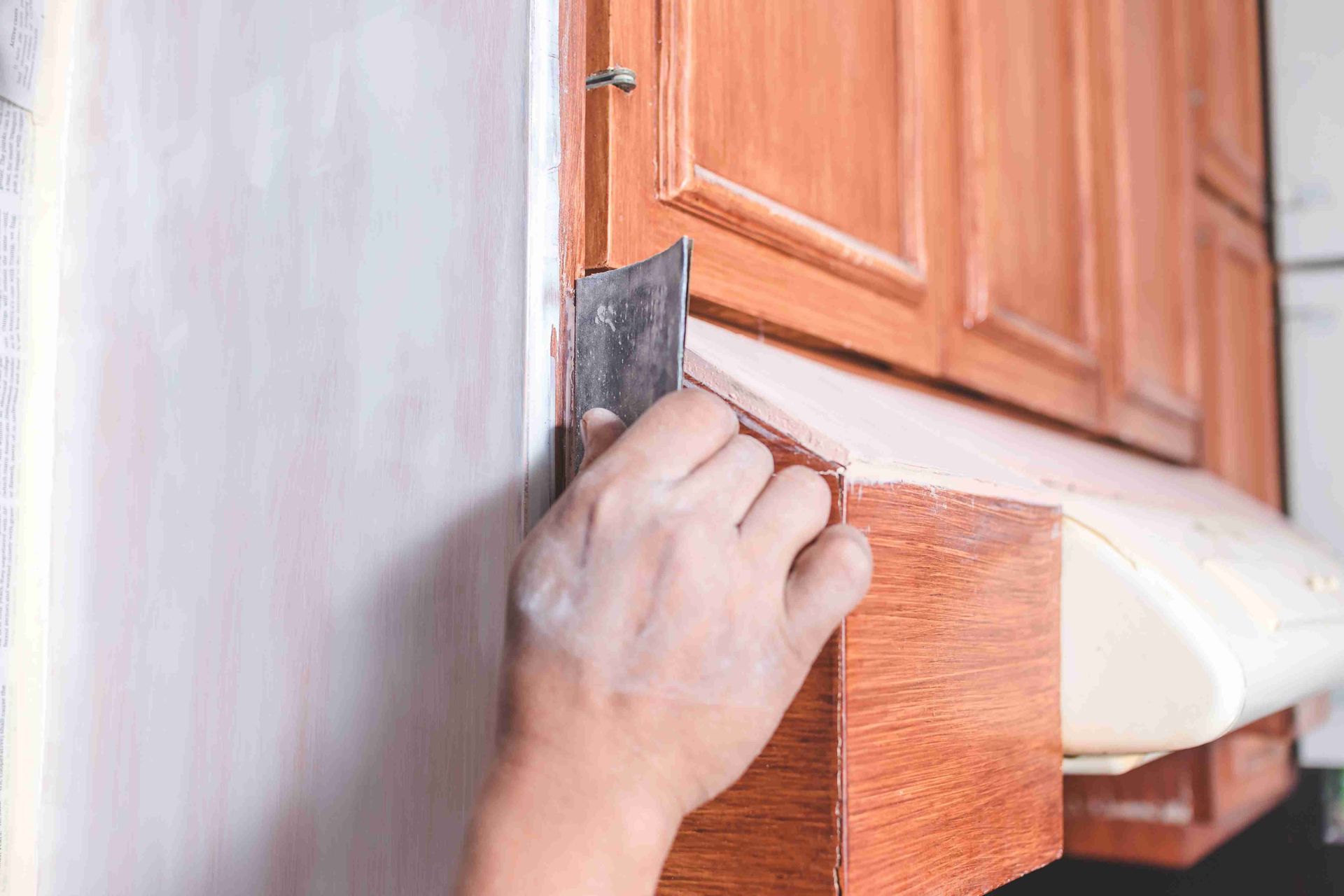 A man working on refinishing cabinets